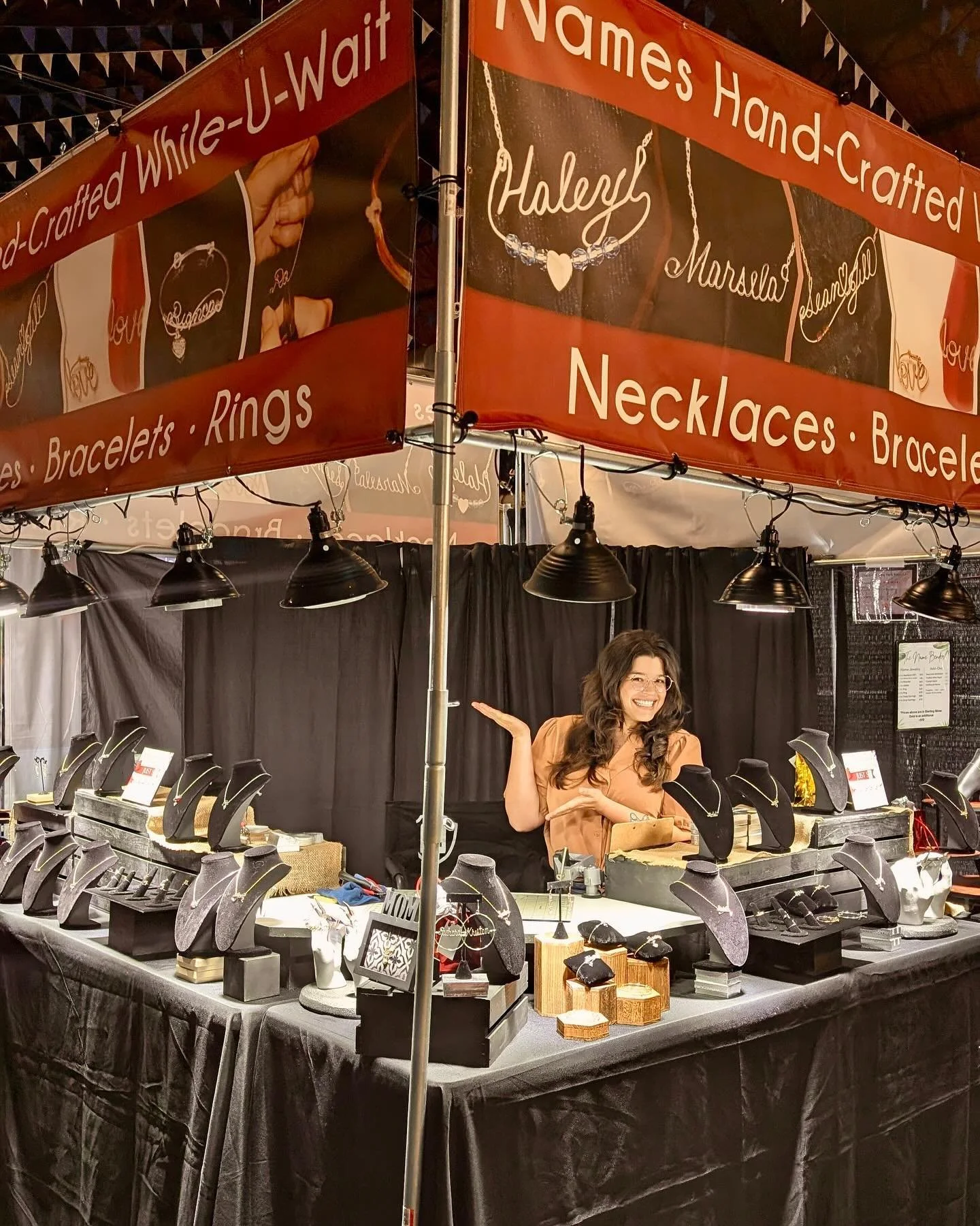 Handcrafted wire jewelry display featuring personalized name charms and custom designs.