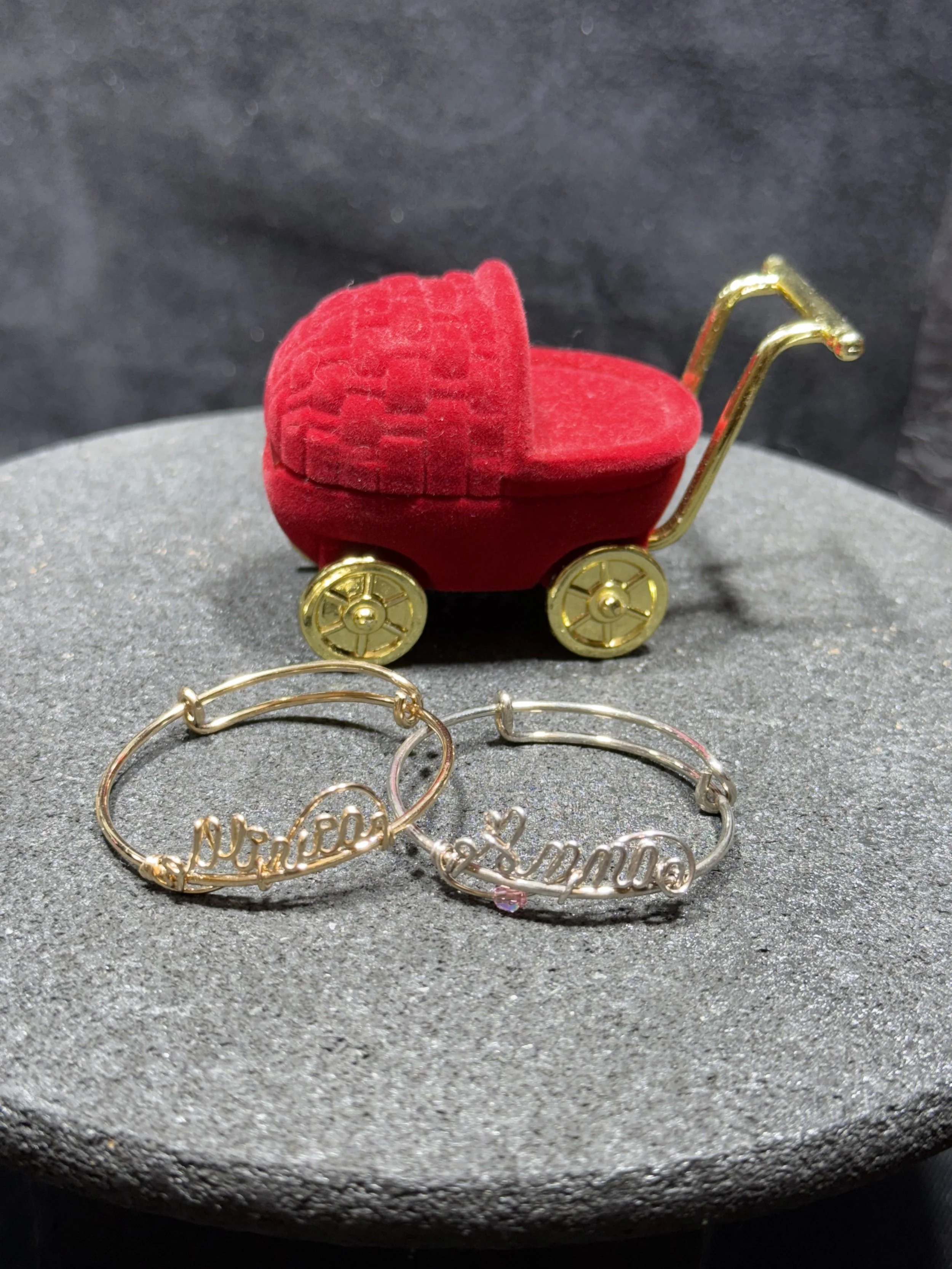 Handcrafted wire bracelet with personalized name and custom charm options.