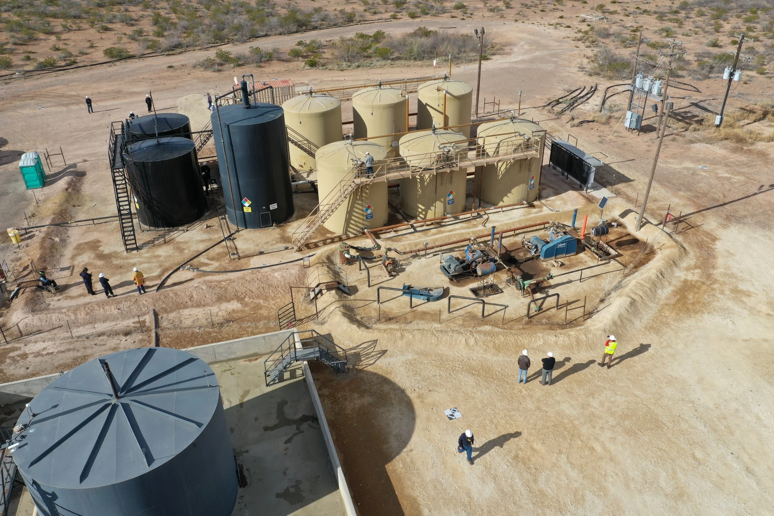 Aerial view of a desert saltwater disposal site with engineers conducting a site inspection.