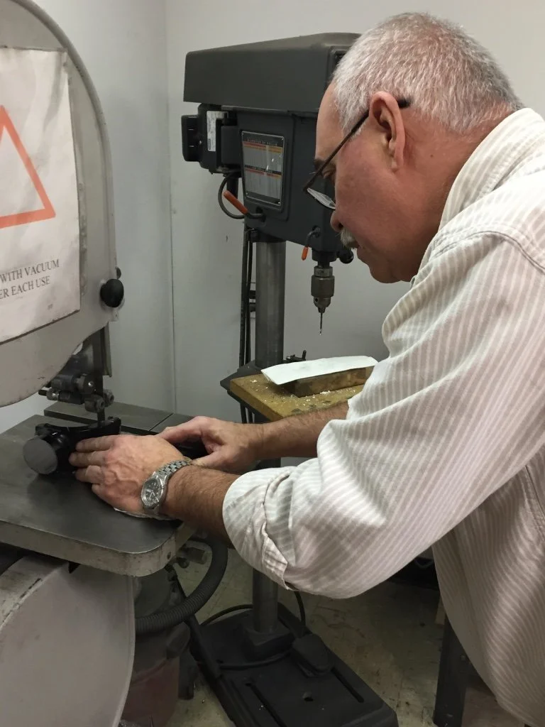 Machinist cutting a test specimen during material preparation for analysis
