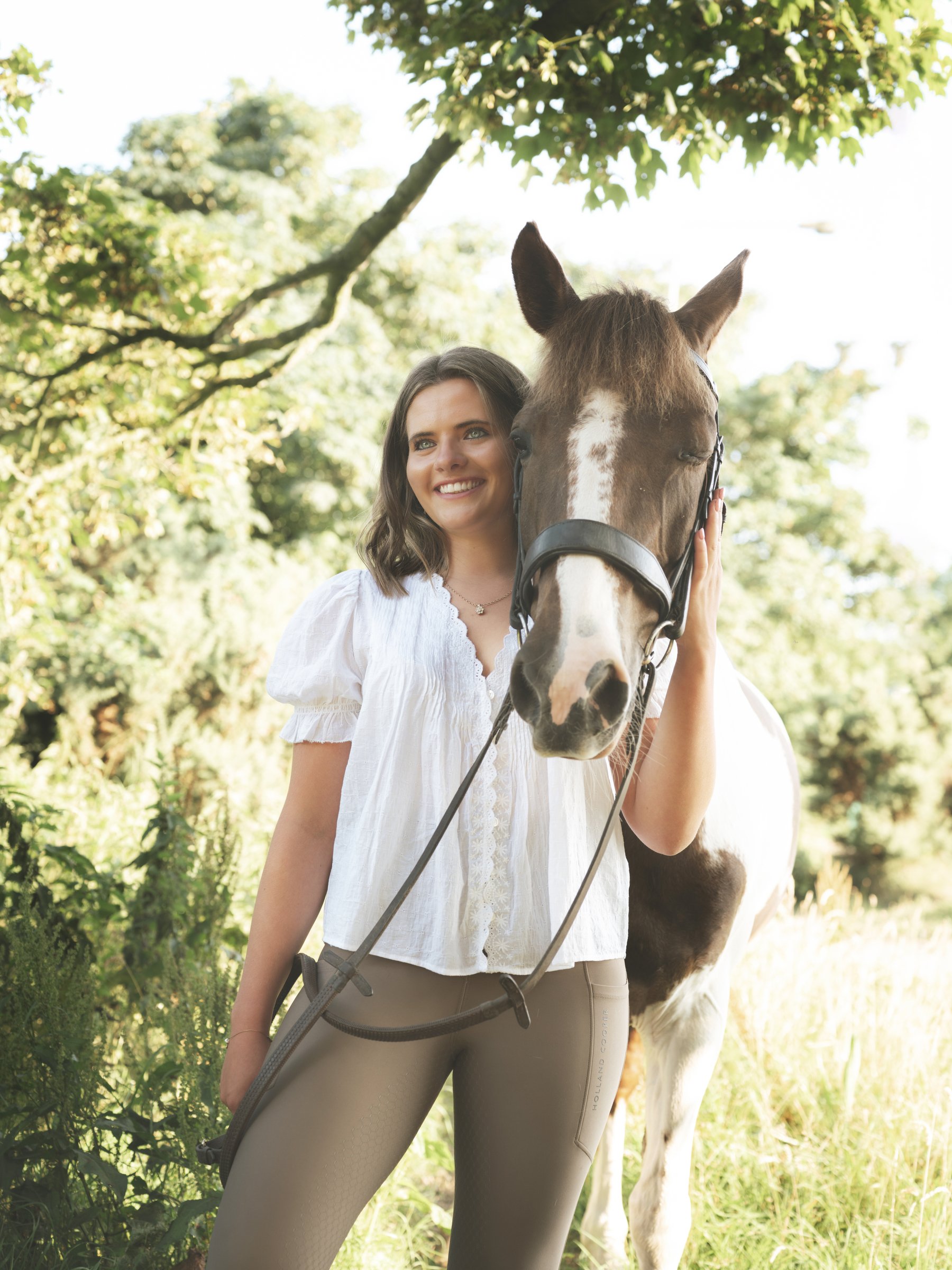 girls standing beside horse