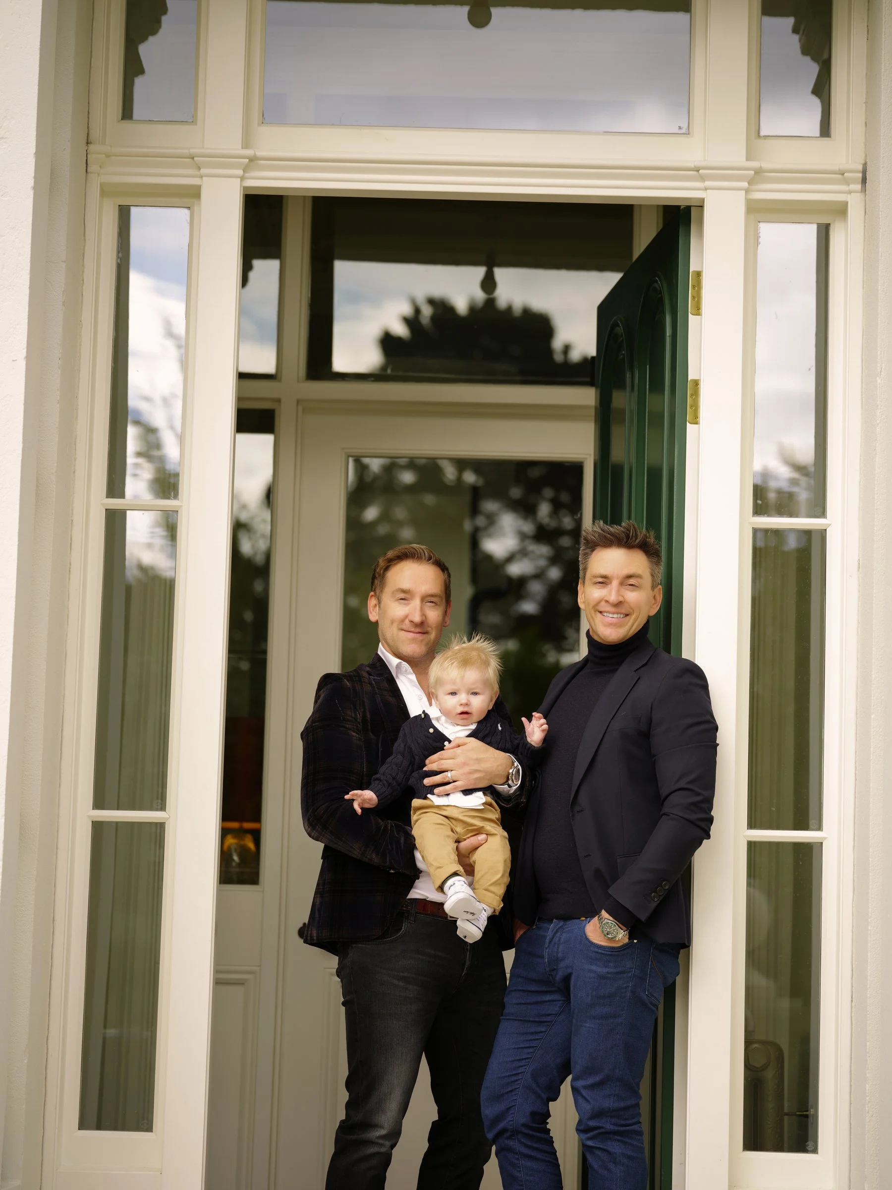 two men with a baby in 
doorway