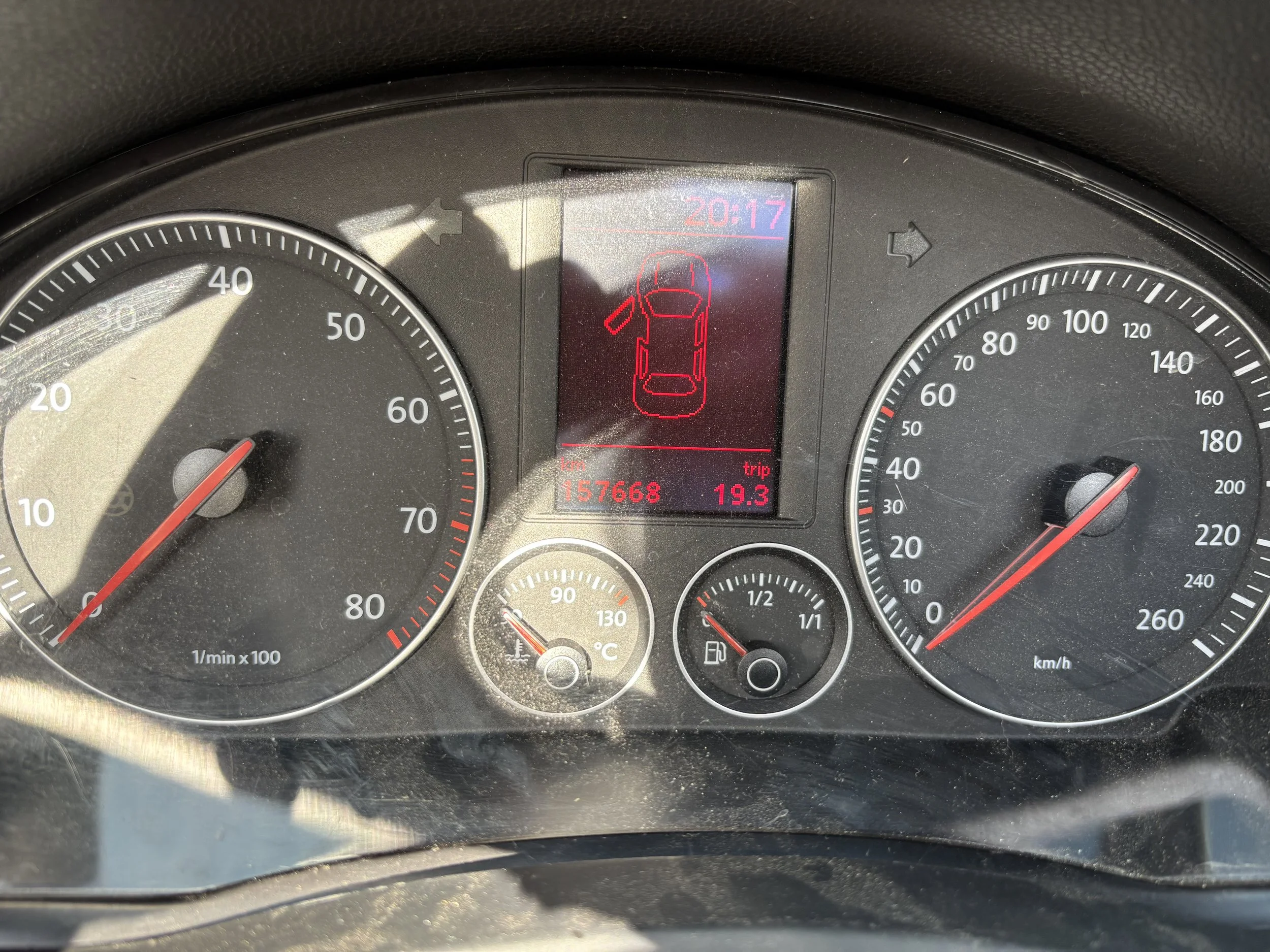 A car inspection report and a vehicle registration document on a gray surface, with a small calculator placed on top of the registration paper.
