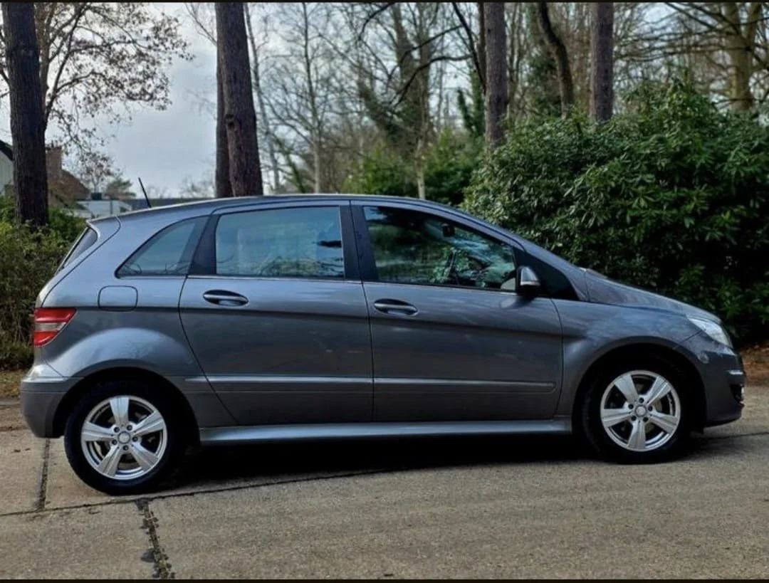 A car inspection report and a vehicle registration document on a gray surface, with a small calculator placed on top of the registration paper.