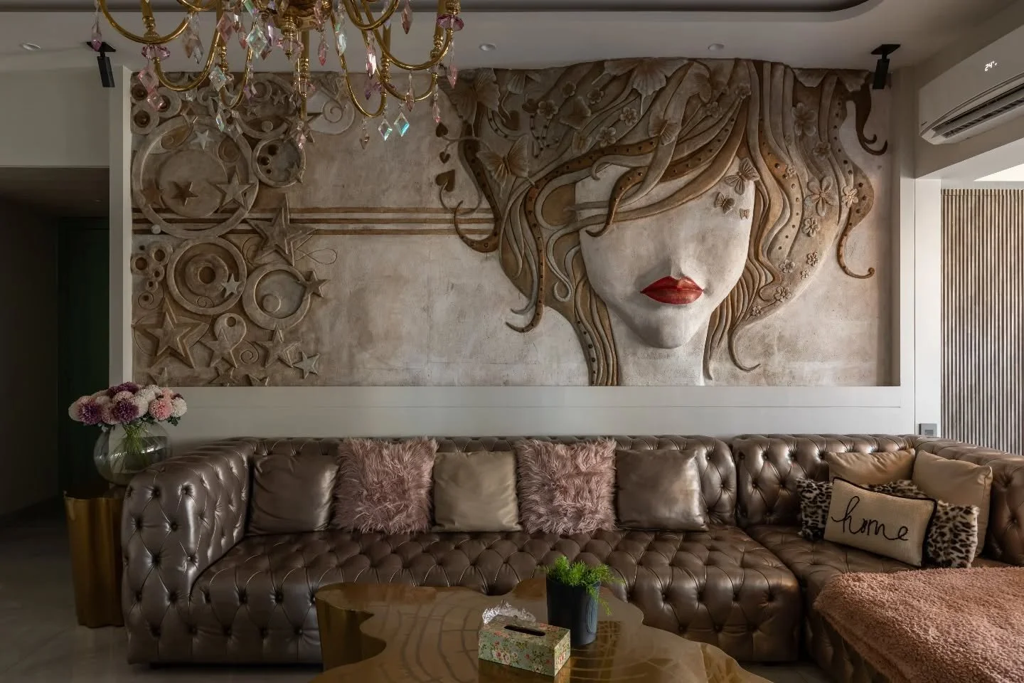 If design had a personality, this home would be a fearless extrovert. Patterns, textures, and art weave the story here &mdash; from the sculpted beige wall with its striking red accent to the reindeer sculpture standing proud in a floral-papered room