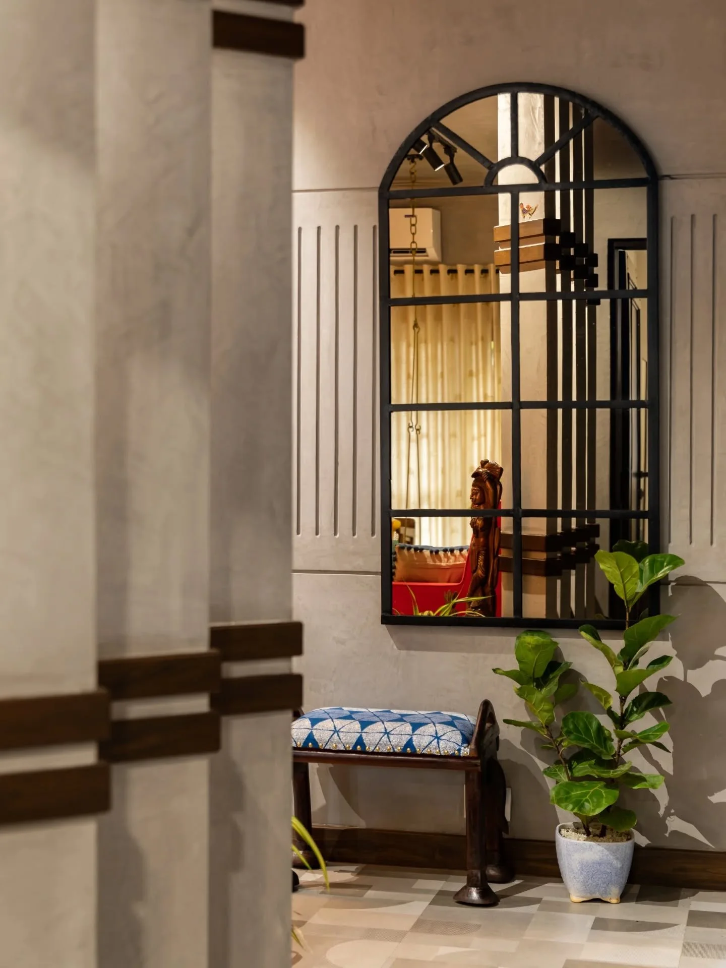 Look closer and the personality reveals itself &mdash; monkey stickers on switch plates, a wooden arc framing circular wall art, a swing echoing the cane console, and tiny crafted touches that feel personal rather than planned. This home thrives in i