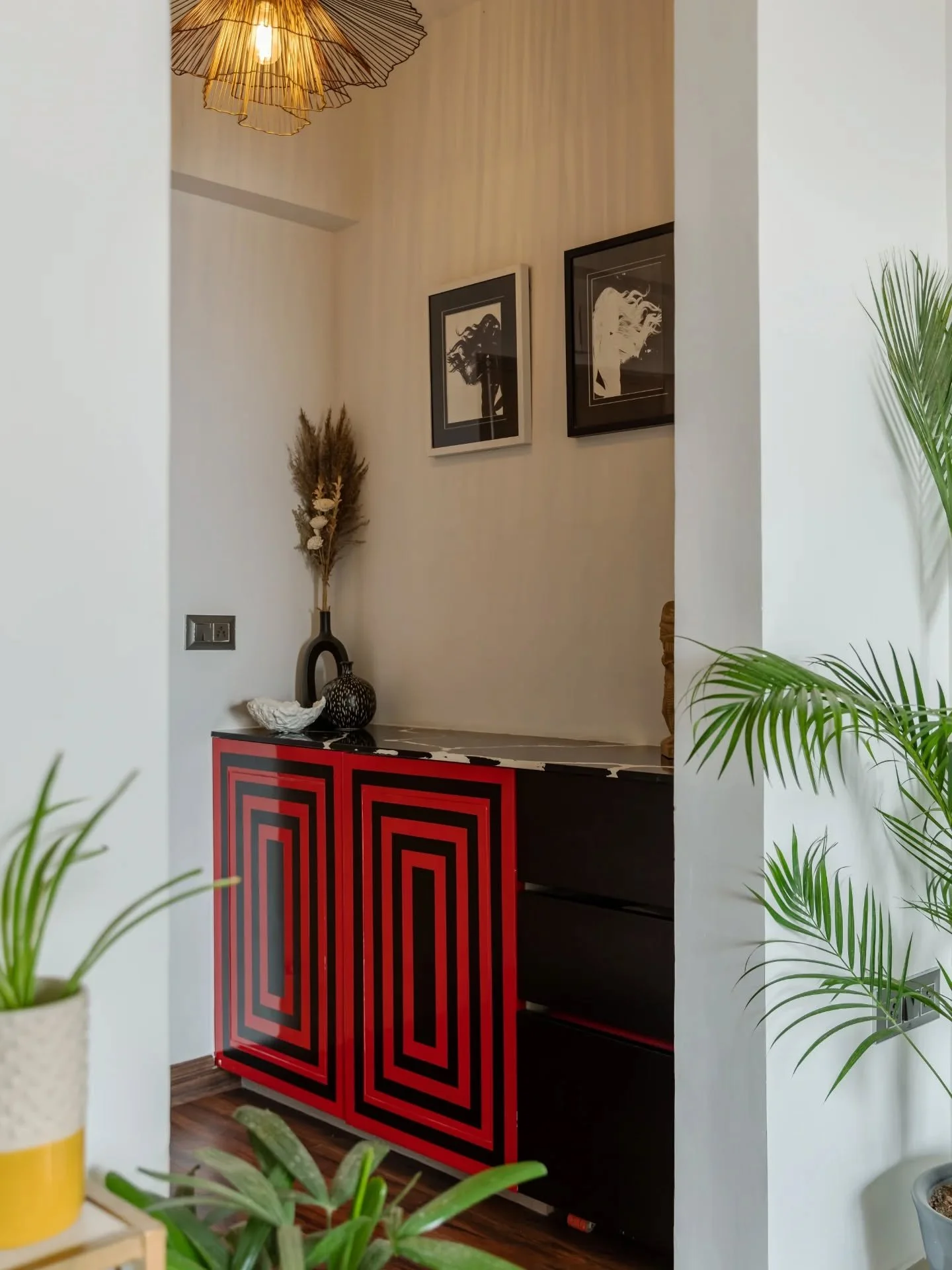 This apartment has a way of keeping things light on its feet. A foyer that plays with bold geometry leads into a living space softened by blush tones and punctuated with black and gold. The kitchen deepens the palette with green and warm light, while