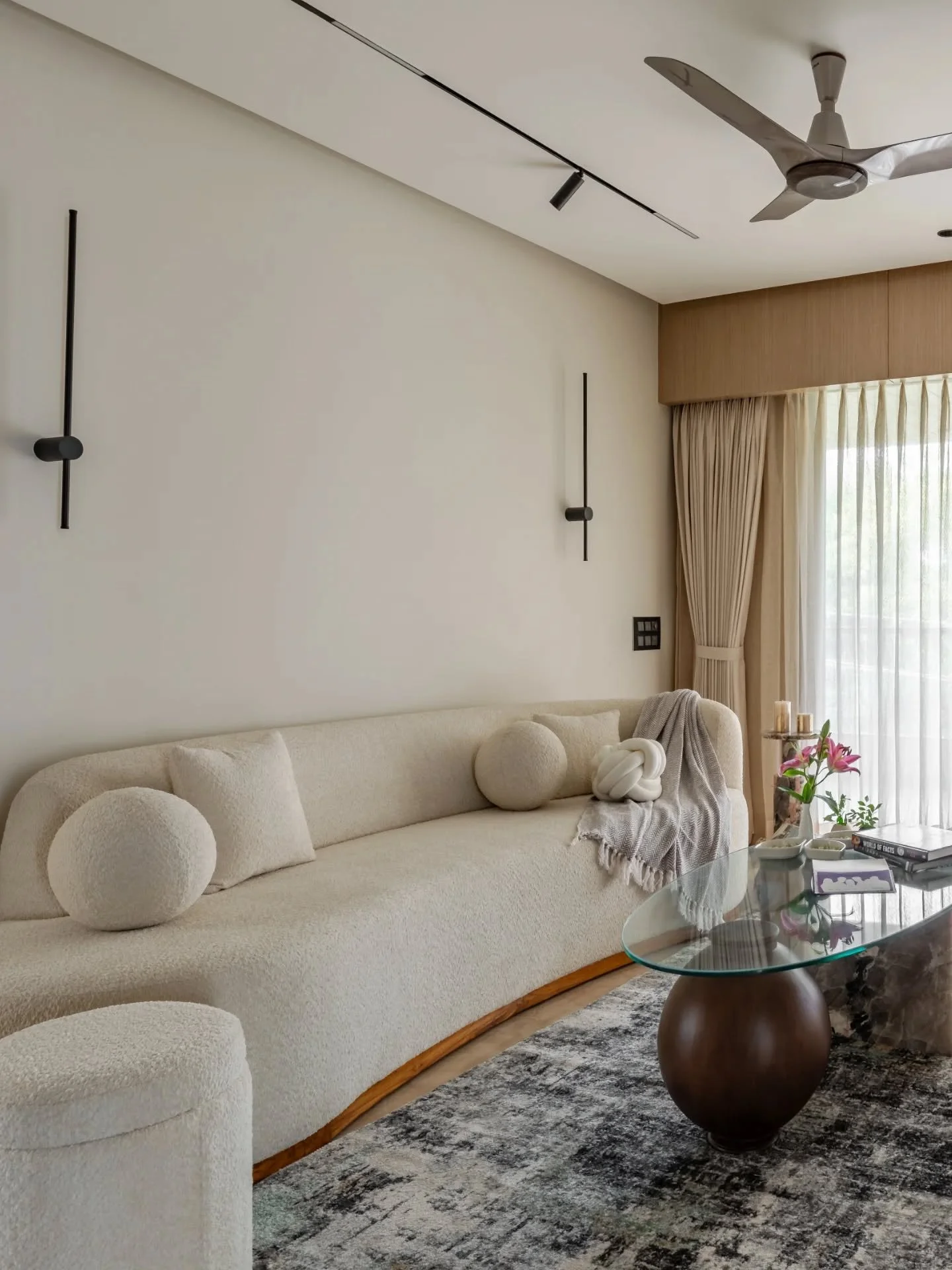 Minimalism gets far more interesting when it carries a sense of heritage with it. Rounded cream seating softens the living room, while the family lounge shifts gears completely with deep blue panelling, traditional furniture, and Mughal-inspired moti