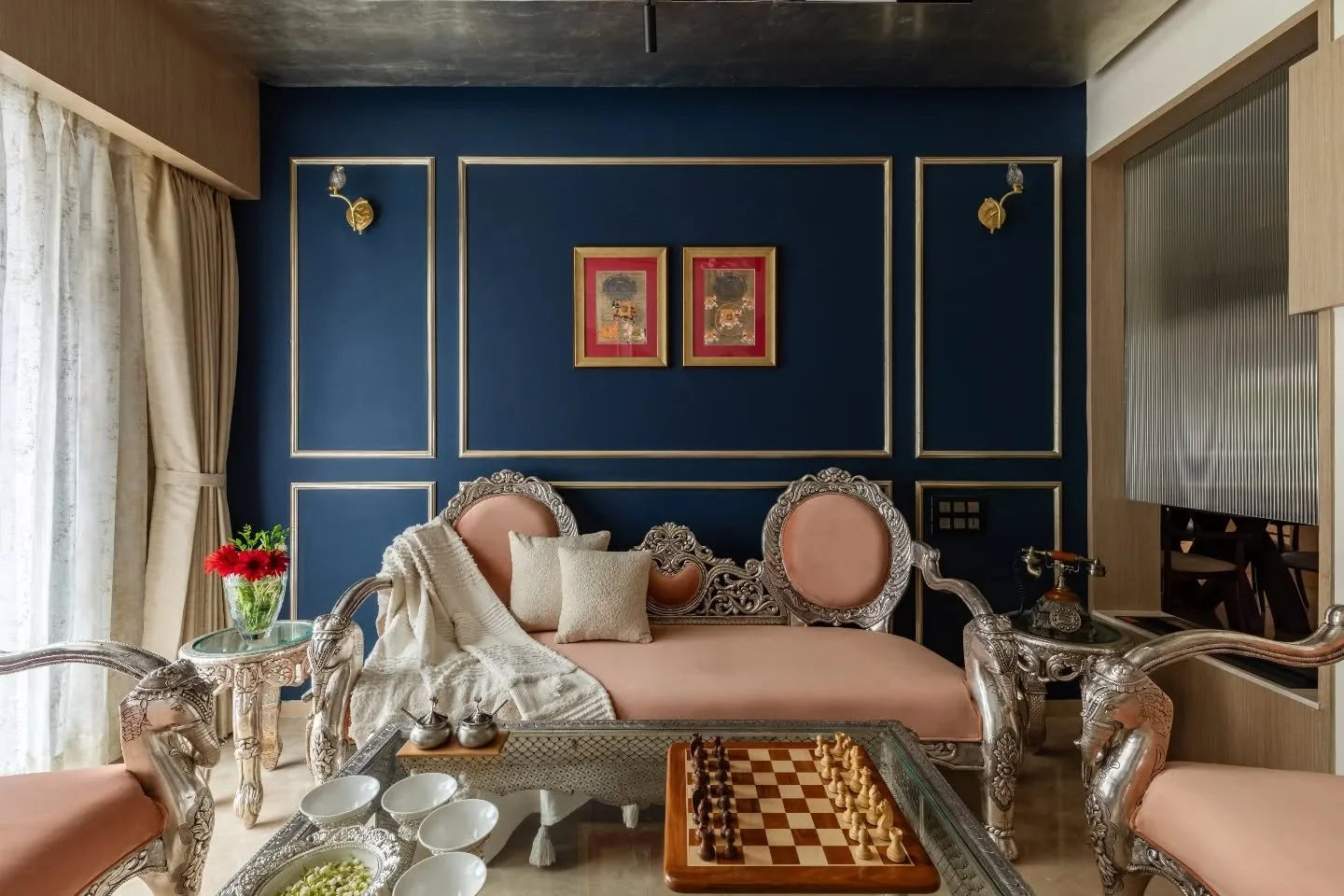 This house understands the art of pause. Calm cream tones, softened edges, and uncluttered spaces create a measured rhythm, until a bold blue wall or a trace of Mughal detailing interrupts the silence just enough. Nothing here competes for attention;