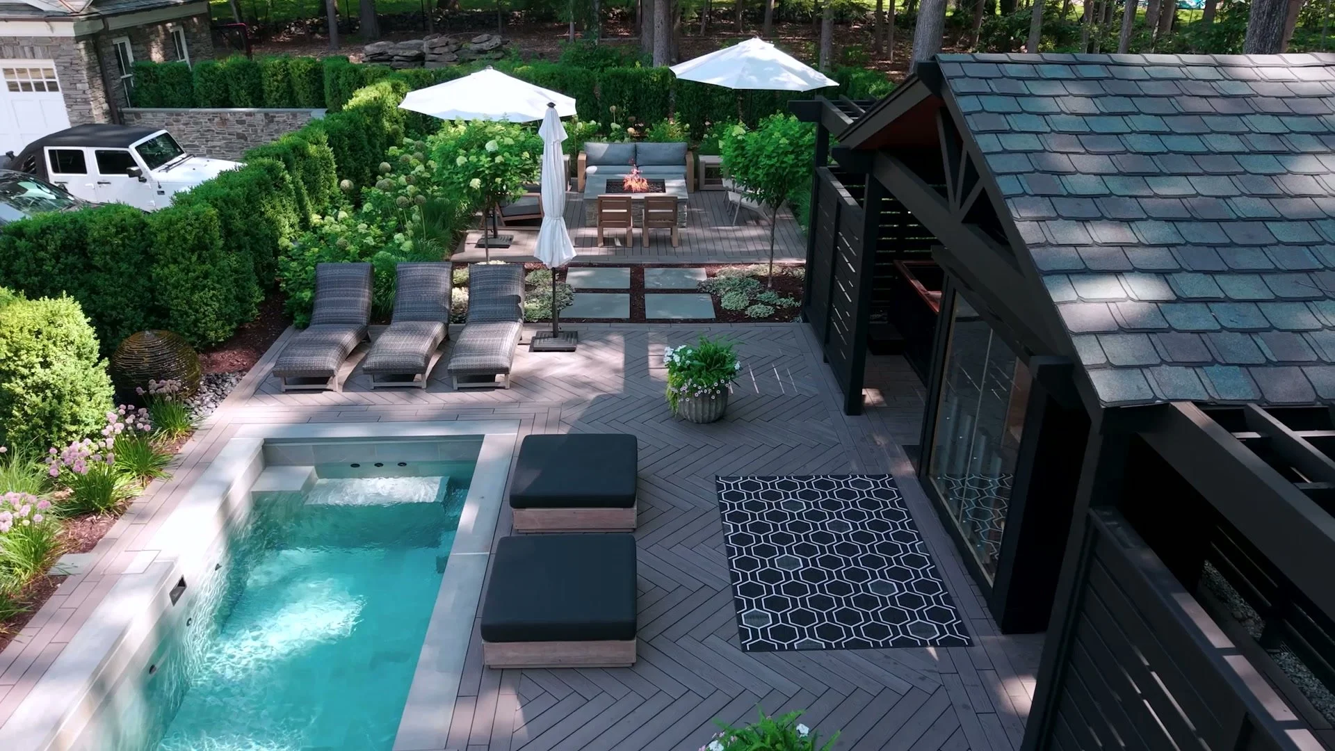 Contemporary outdoor kitchen beside plunge pool and seating area in Allendale, NJ