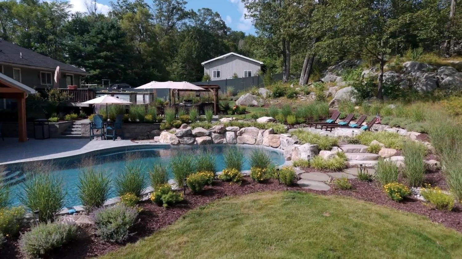 Backyard renovation featuring boulderwork and wild-refined planting in West Milford, NJ.jpg