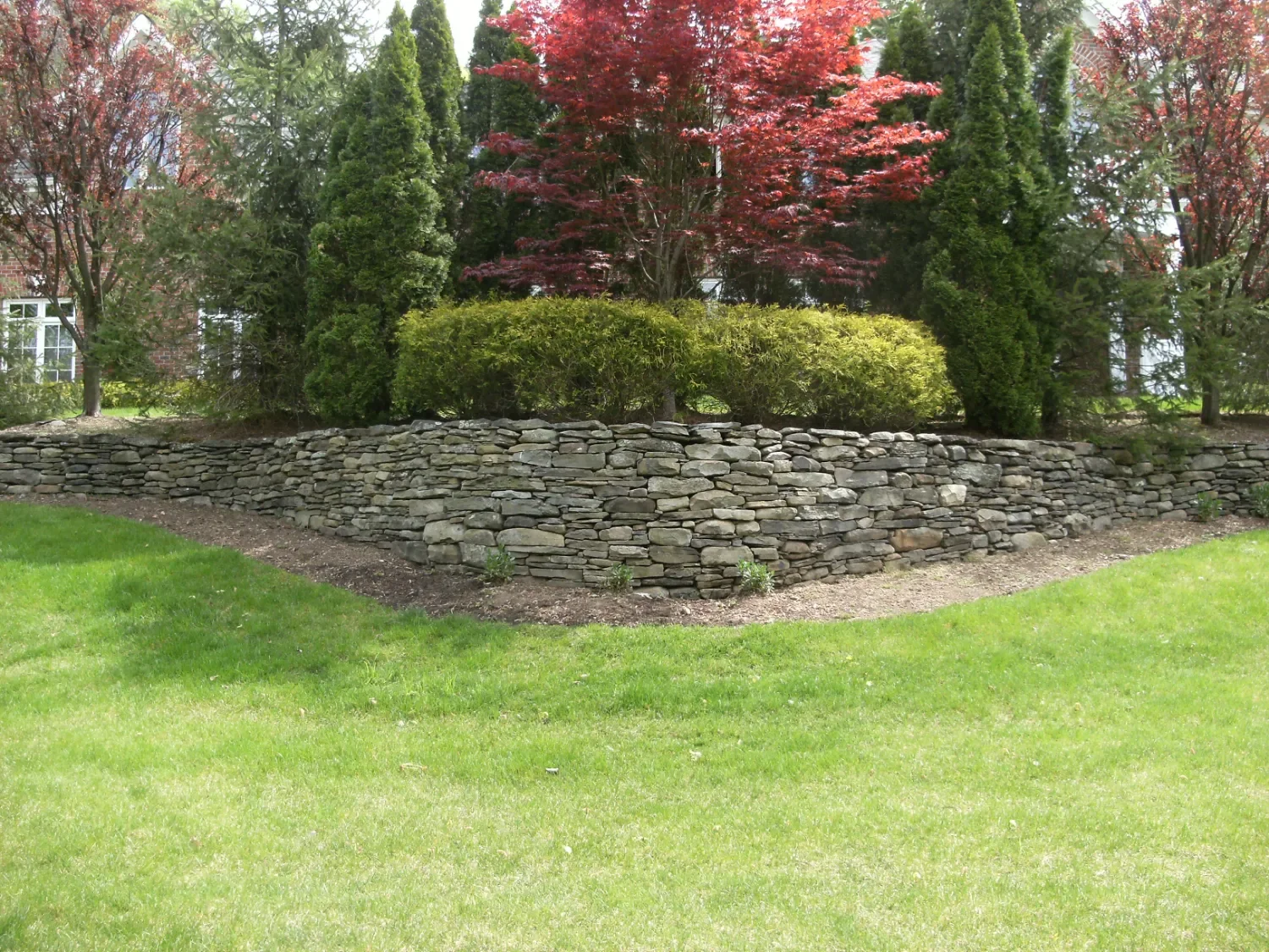 Retaining wall integrated with steps and hardscape details near a patio in Ridgewood, NJ