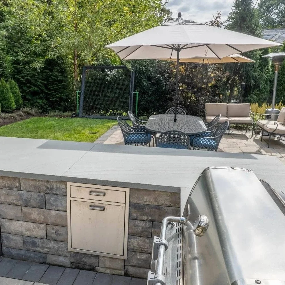A luxury backyard entertainment space with a professionally installed outdoor kitchen and seating area in Franklin Lakes, NJ