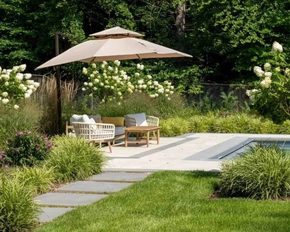 A beautiful backyard featuring thoughtful landscape design with layered garden plantings and natural stone pathways in Allendale, NJ