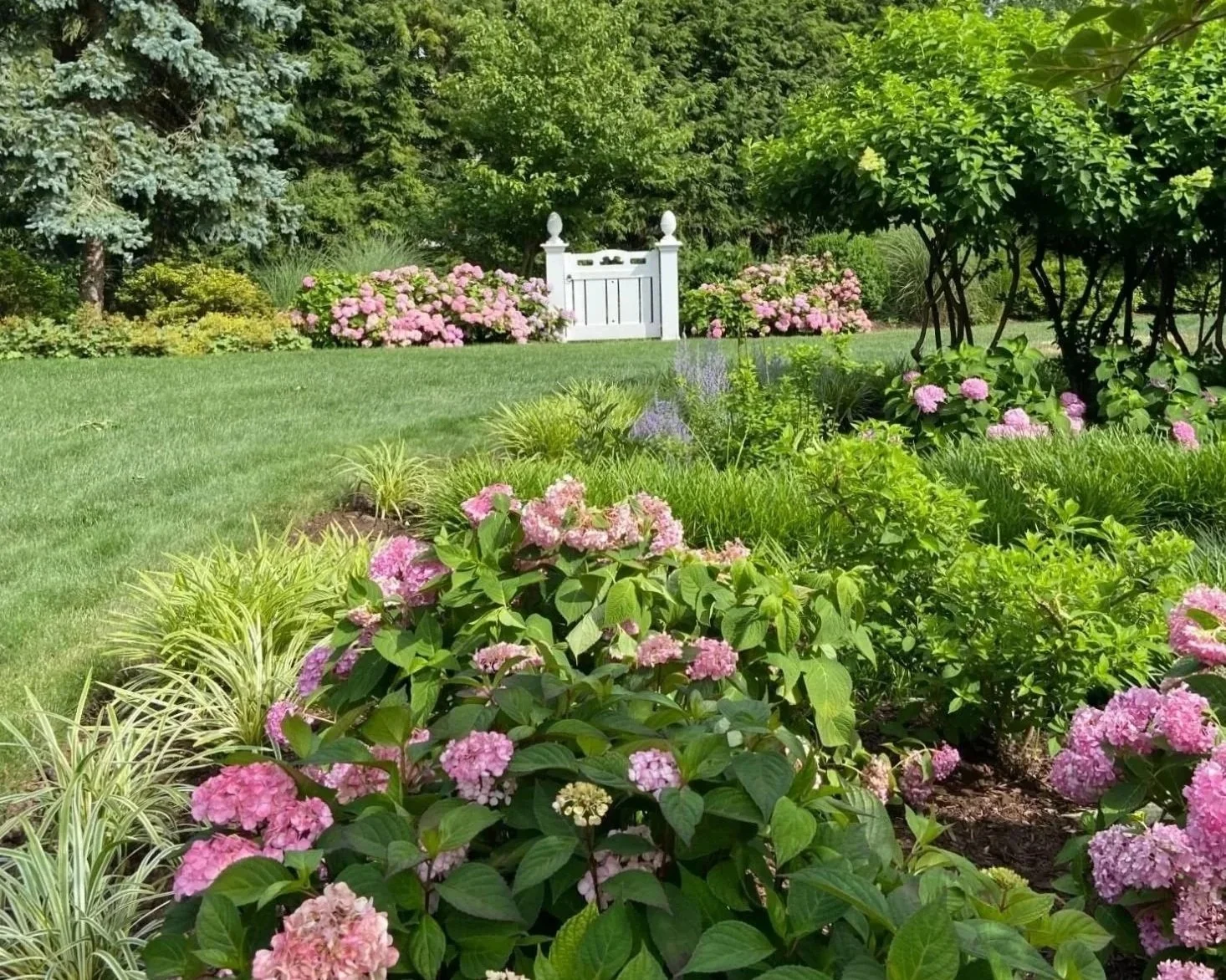 A stunning residential yard designed by a trusted landscaping company near me with seasonal plantings and garden pathways in Ho-Ho-Kus, NJ