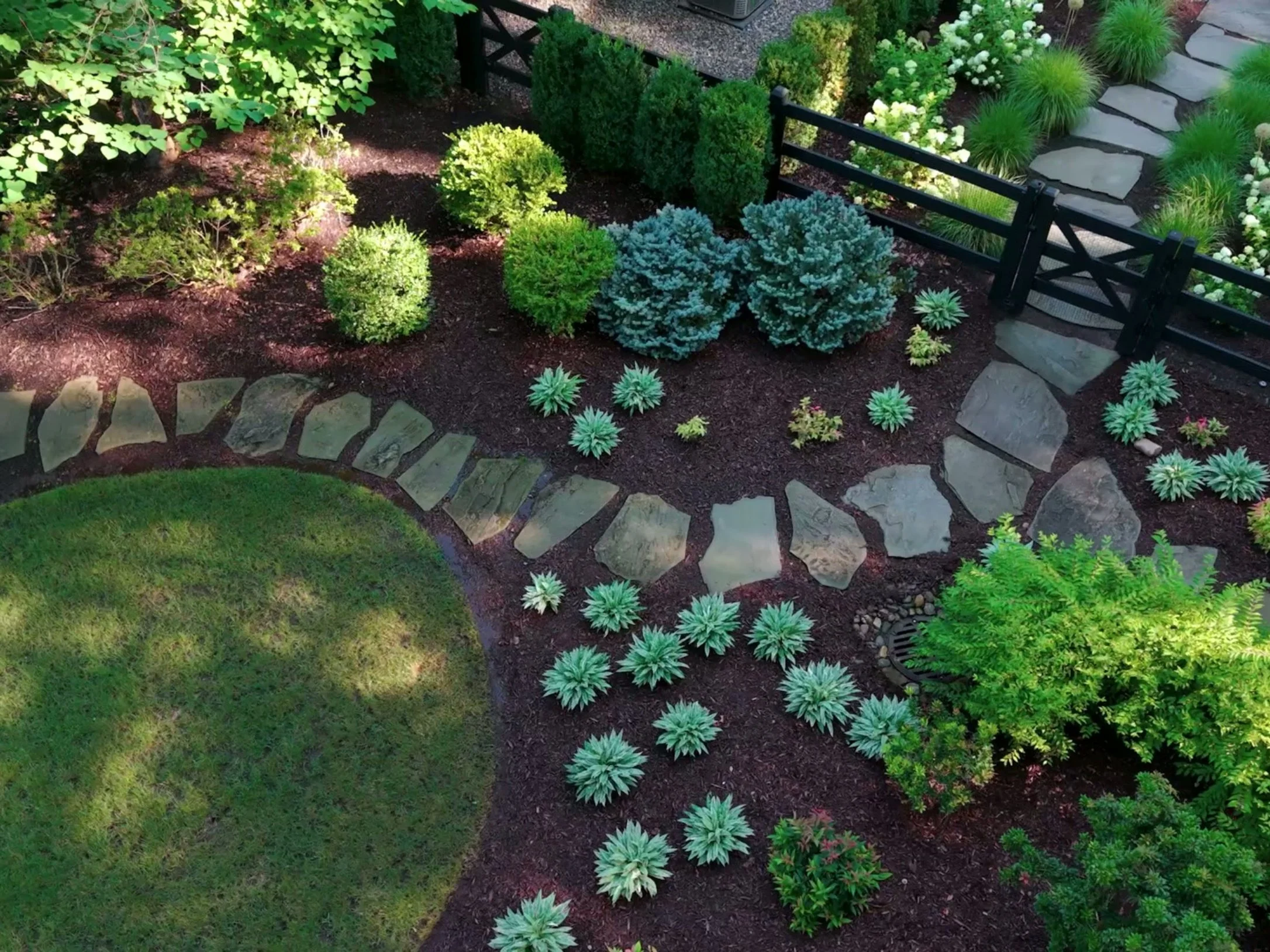 Garden path with stepping stones winding through lush plantings.jpg