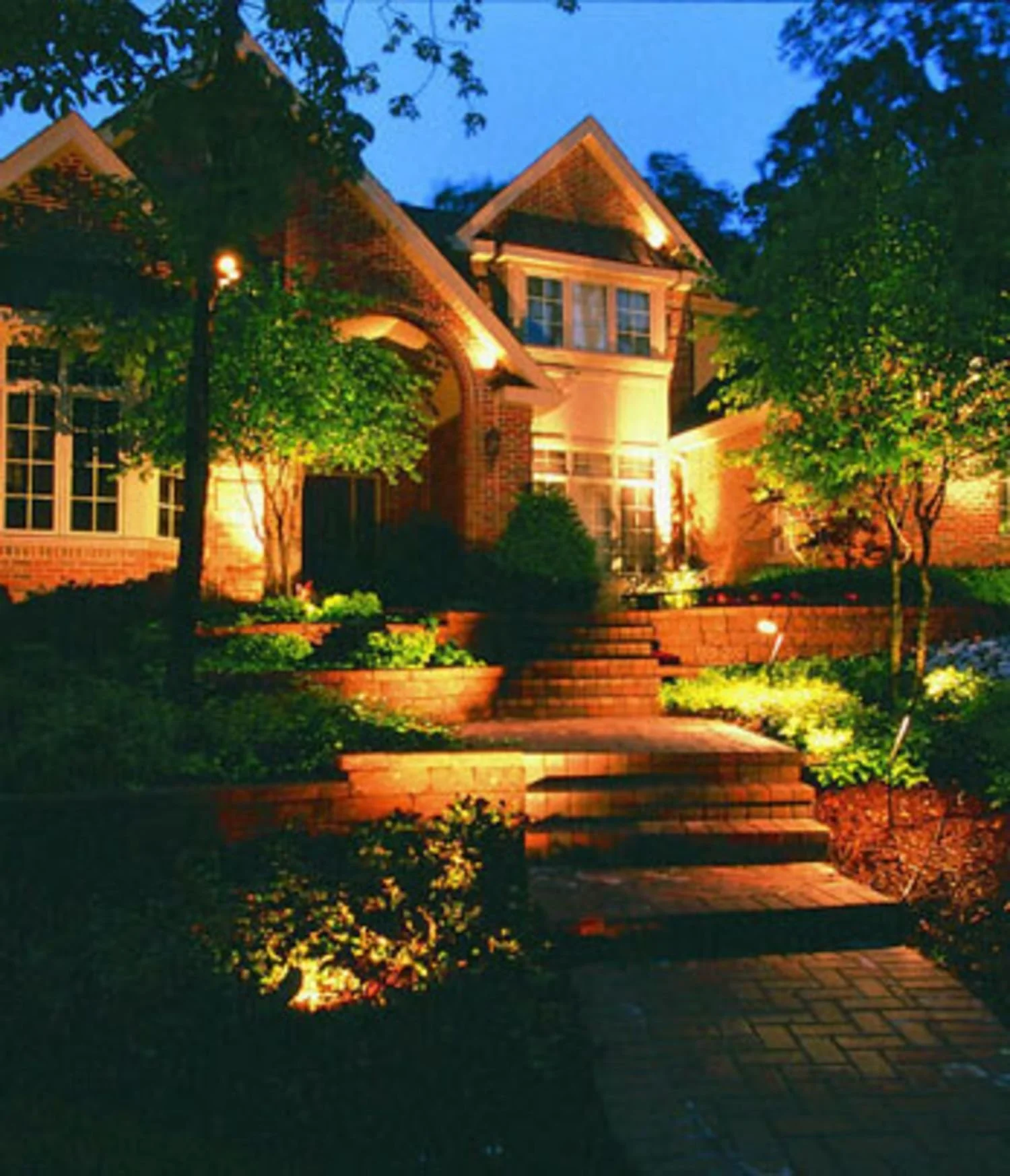 A front entry softly illuminated with landscape lighting in Franklin Lakes, NJ