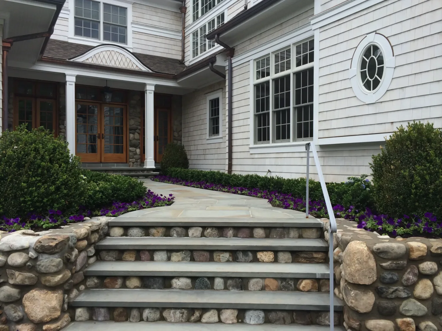 paver walkway integrated into a landscaped slope with stone risers in Saddle River, NJ