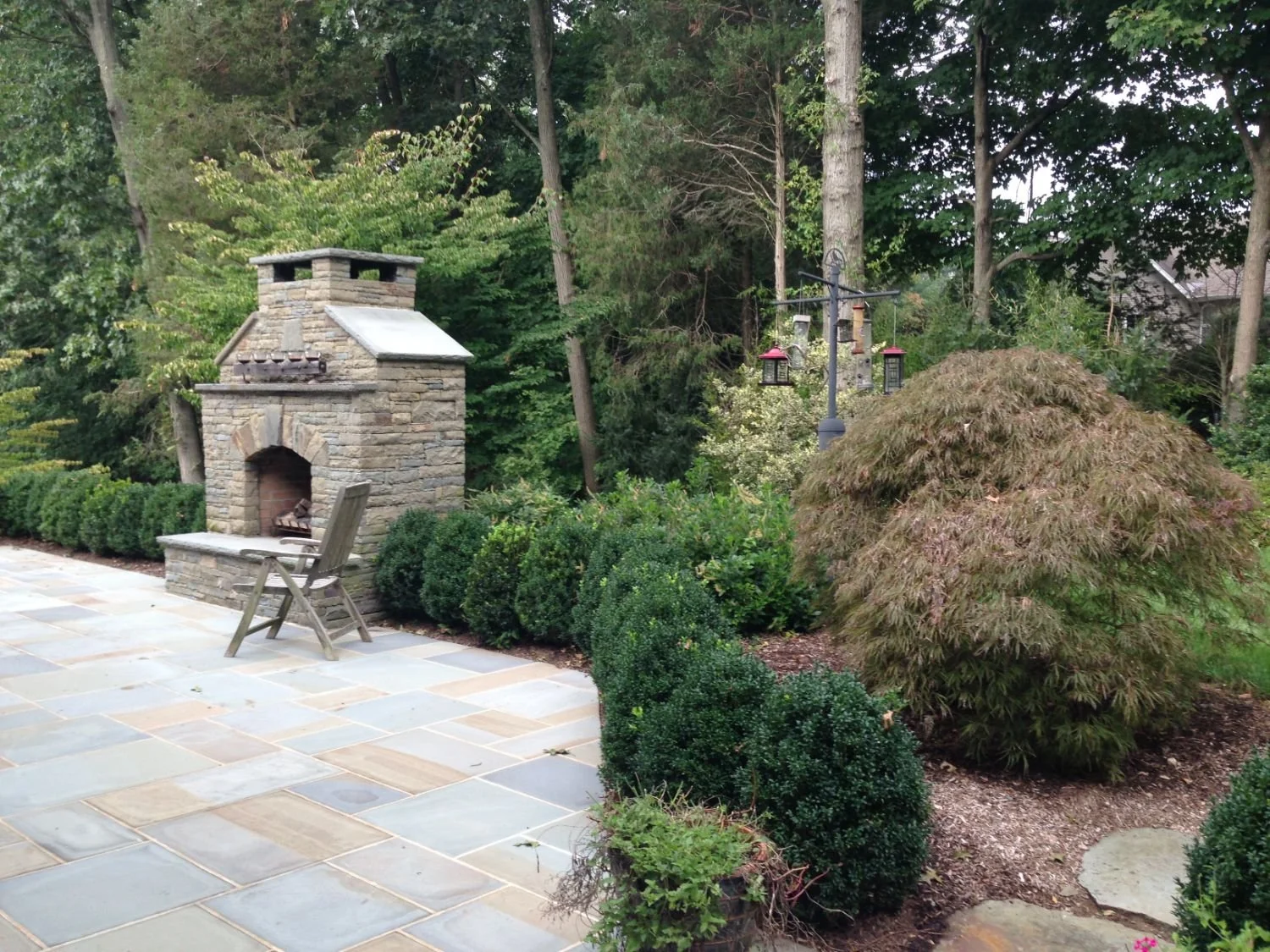 This outdoor living space features a fire pit surrounded by deep seating in Glen Rock, NJ