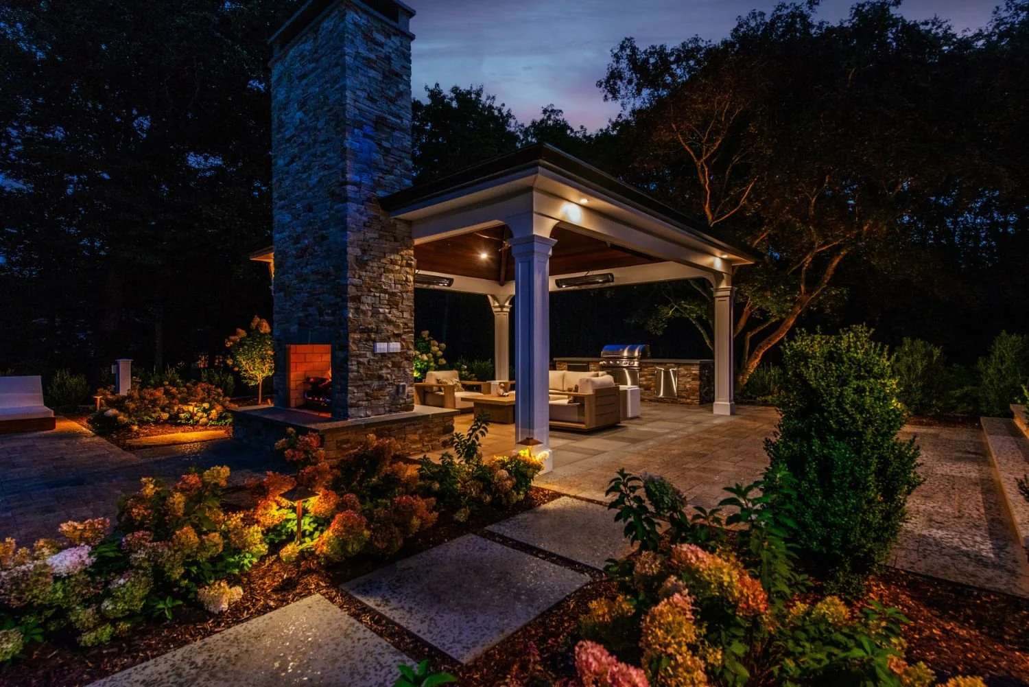 Landscape lighting guiding steps and garden beds toward the home in Glen Rock, NJ