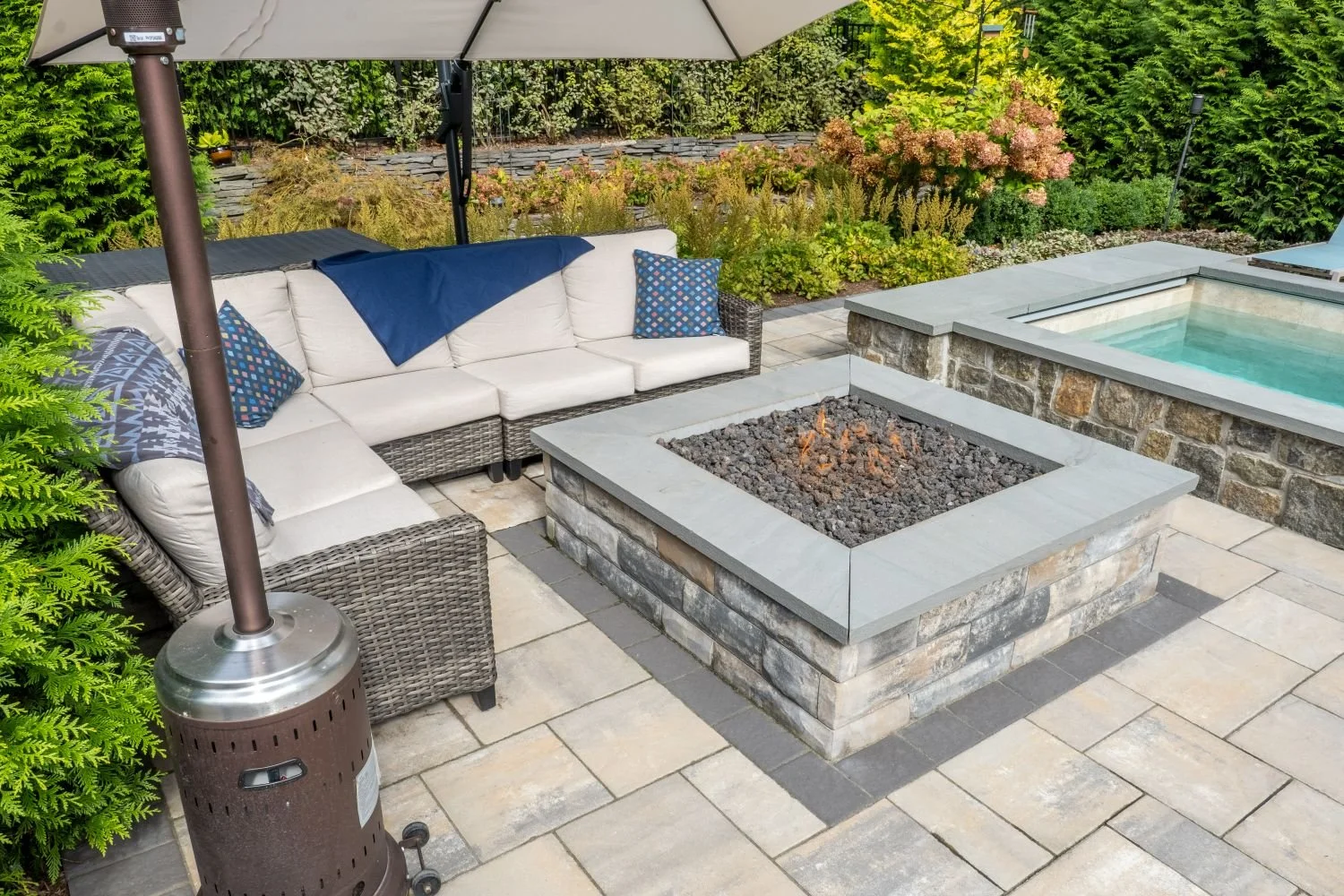 A fire pit placed near outdoor dining and lounge seating in Wyckoff, NJ