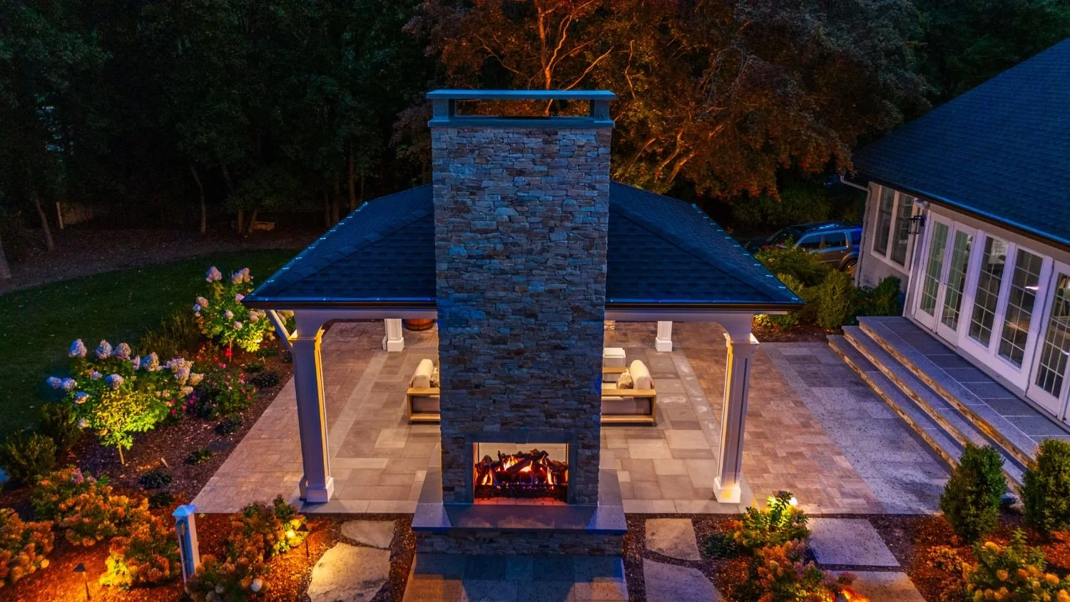 A backyard retreat featuring a fire pit framed by greenery in Ridgewood, NJ