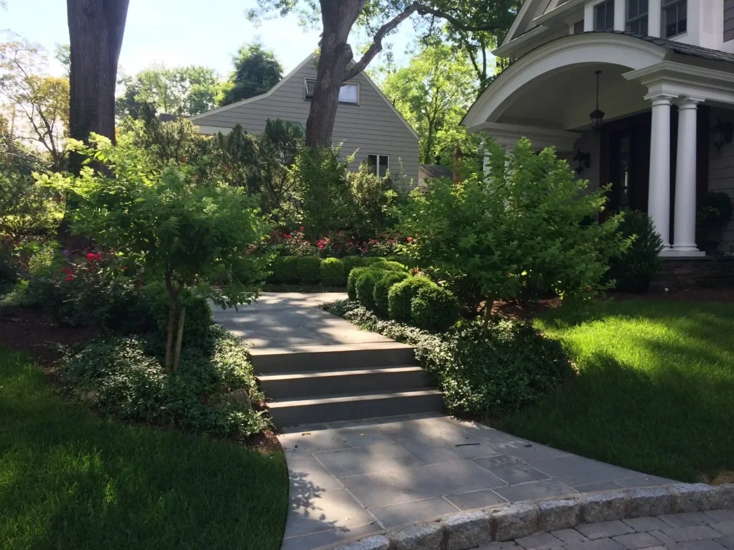 classic courtyard layout featuring a straight paver walkway and soft greenery in Ho-Ho-Kus, NJ