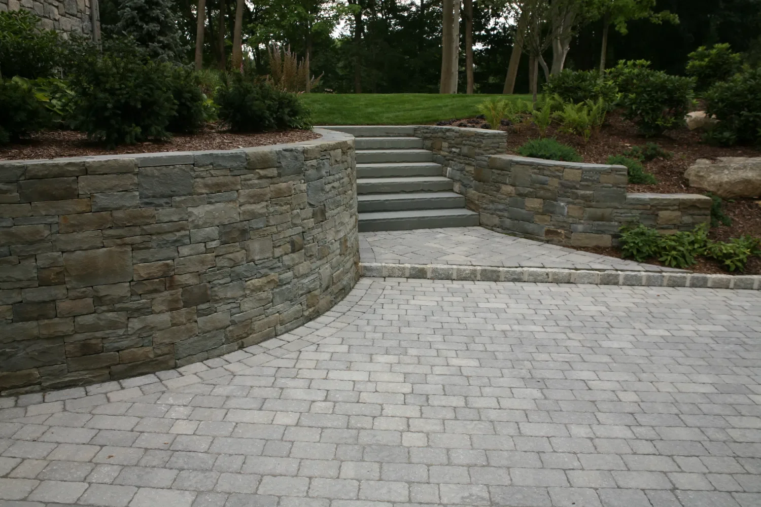 Retaining wall combined with garden beds and steps near a residential pool in Ridgewood, NJ