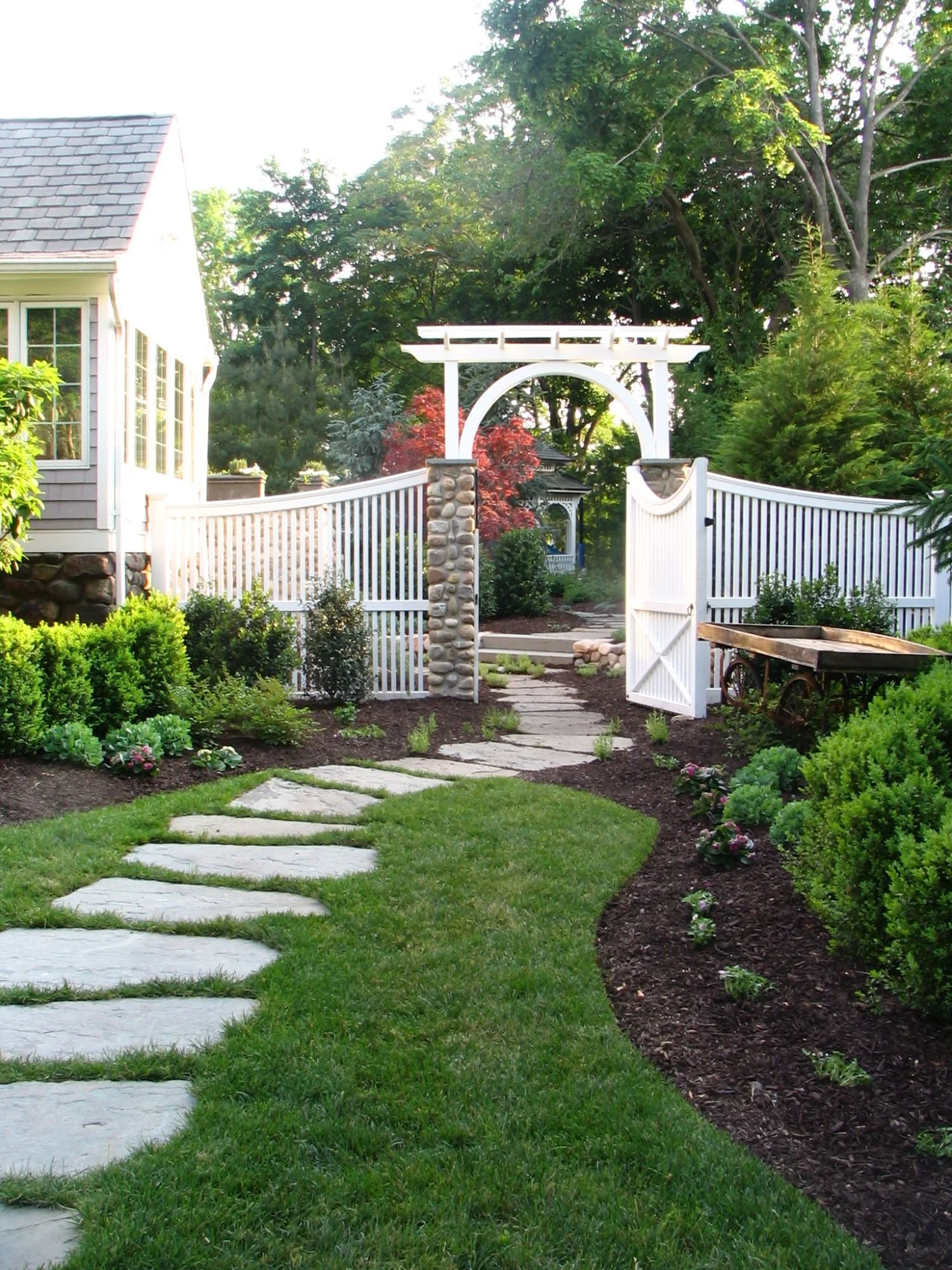 Curved stepping stones forming a natural pathway through a garden landscape in Oradell, NJ