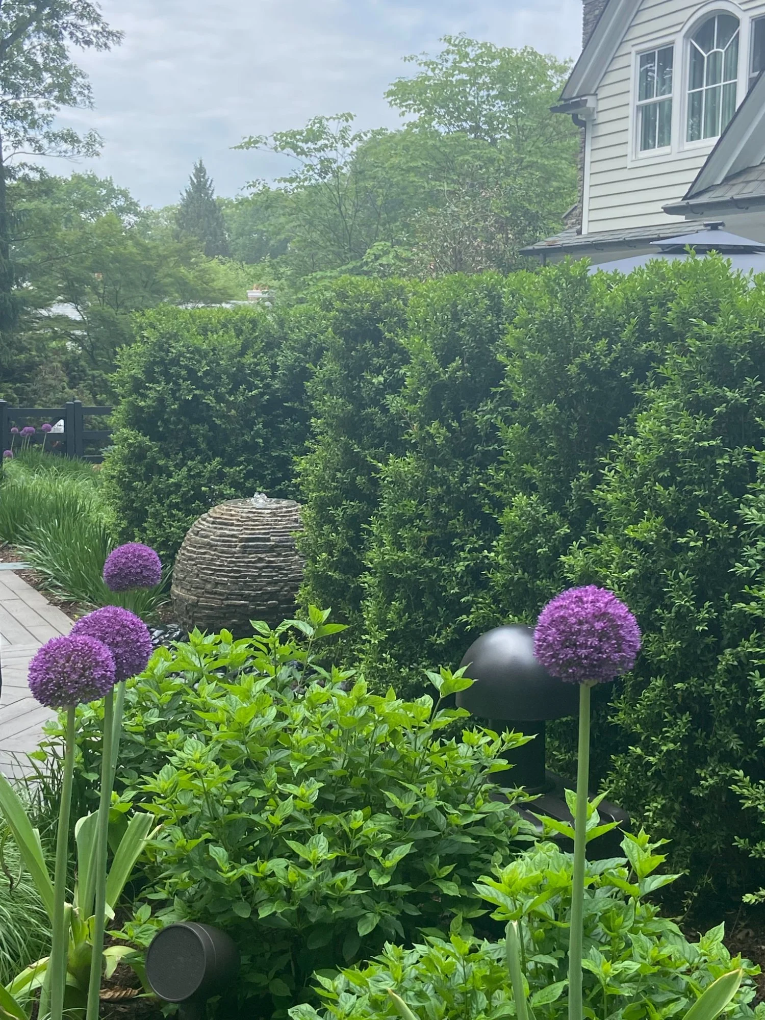 Stacked stone waterfall feeding into a clear blue backyard pond in Franklin Lakes, NJ