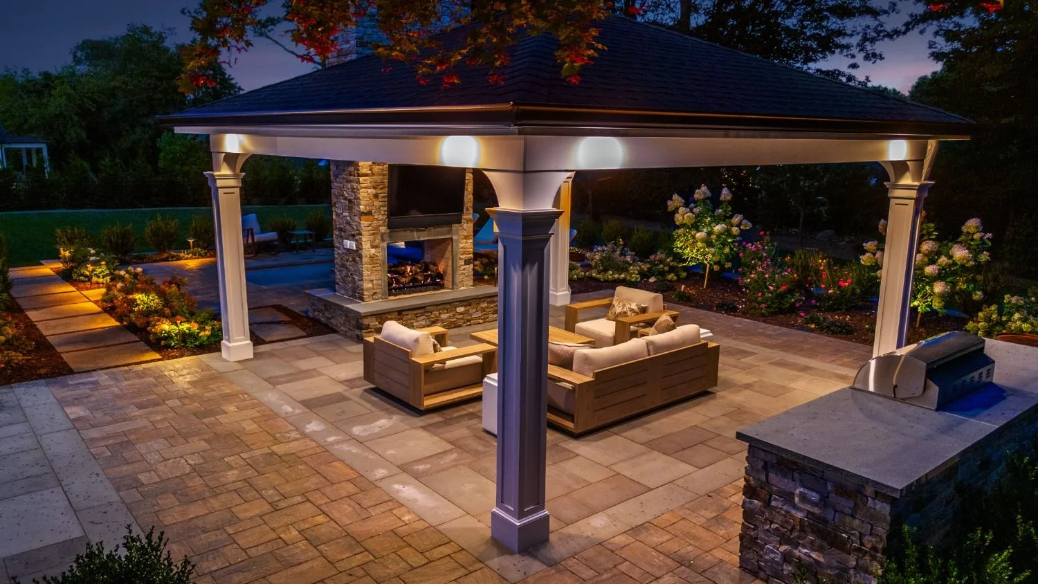 Warm landscape lighting highlighting an outdoor seating pavilion in Wyckoff, NJ