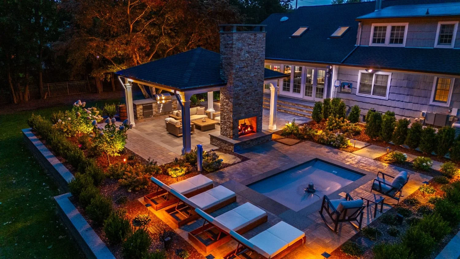 An outdoor living space enhanced by layered landscape lighting in Wyckoff, NJ