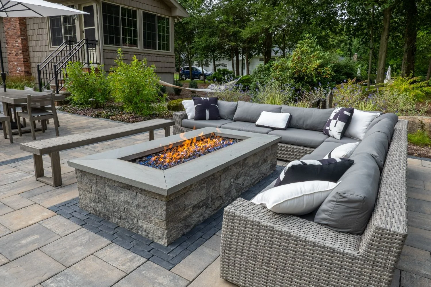 A custom stone fire pit set within a comfortable patio seating area in Ridgewood, NJ