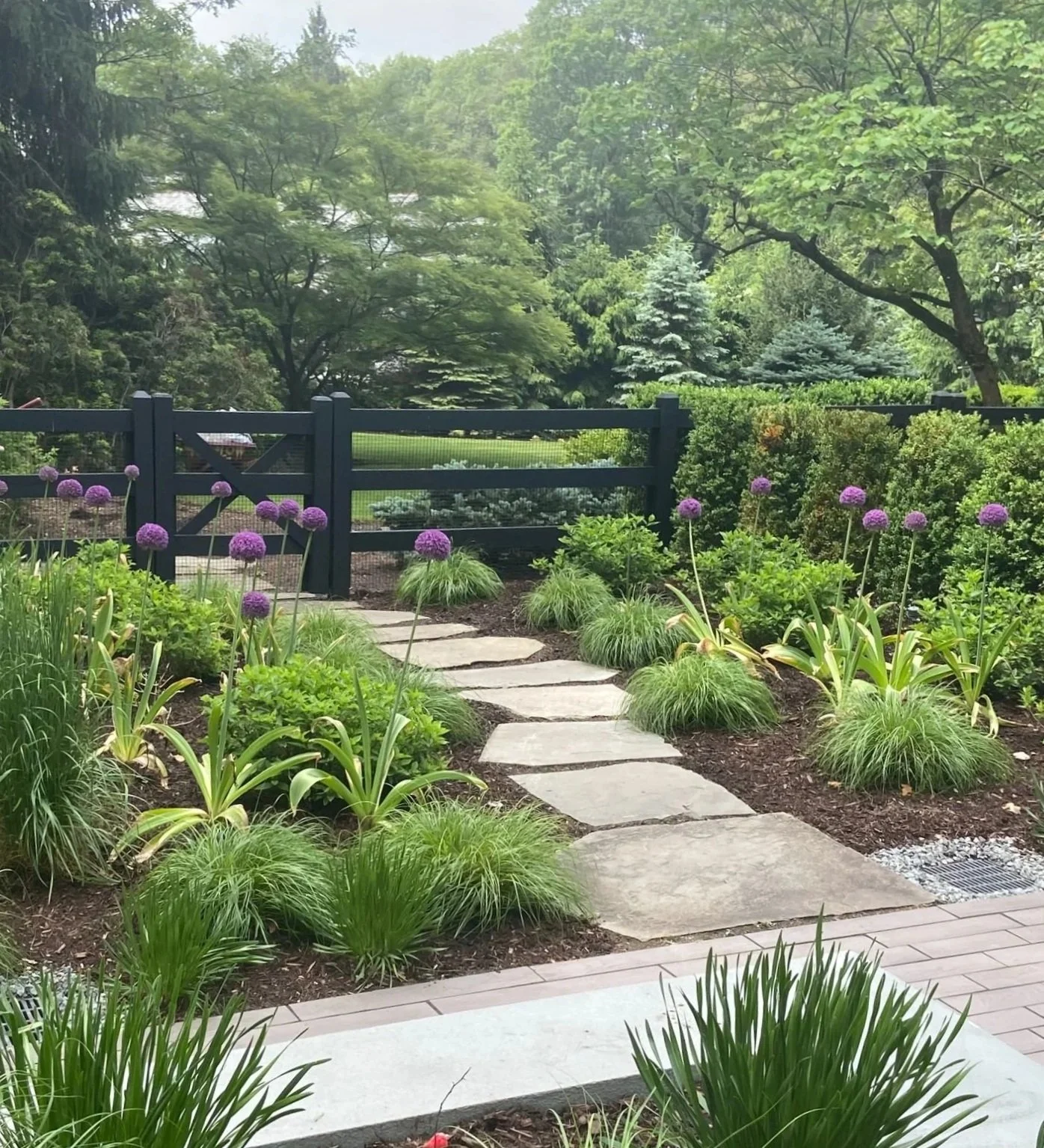 A natural pathway integrated with low retaining walls and garden beds in Franklin Lakes, NJ