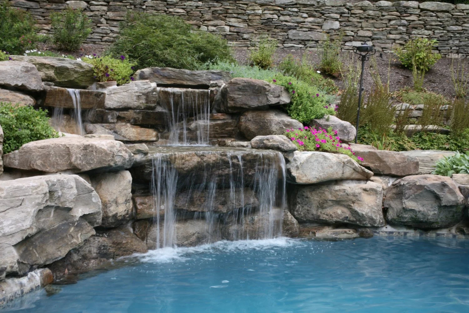 Natural stone waterfall feature built into a garden slope in Ho-Ho-Kus, NJ