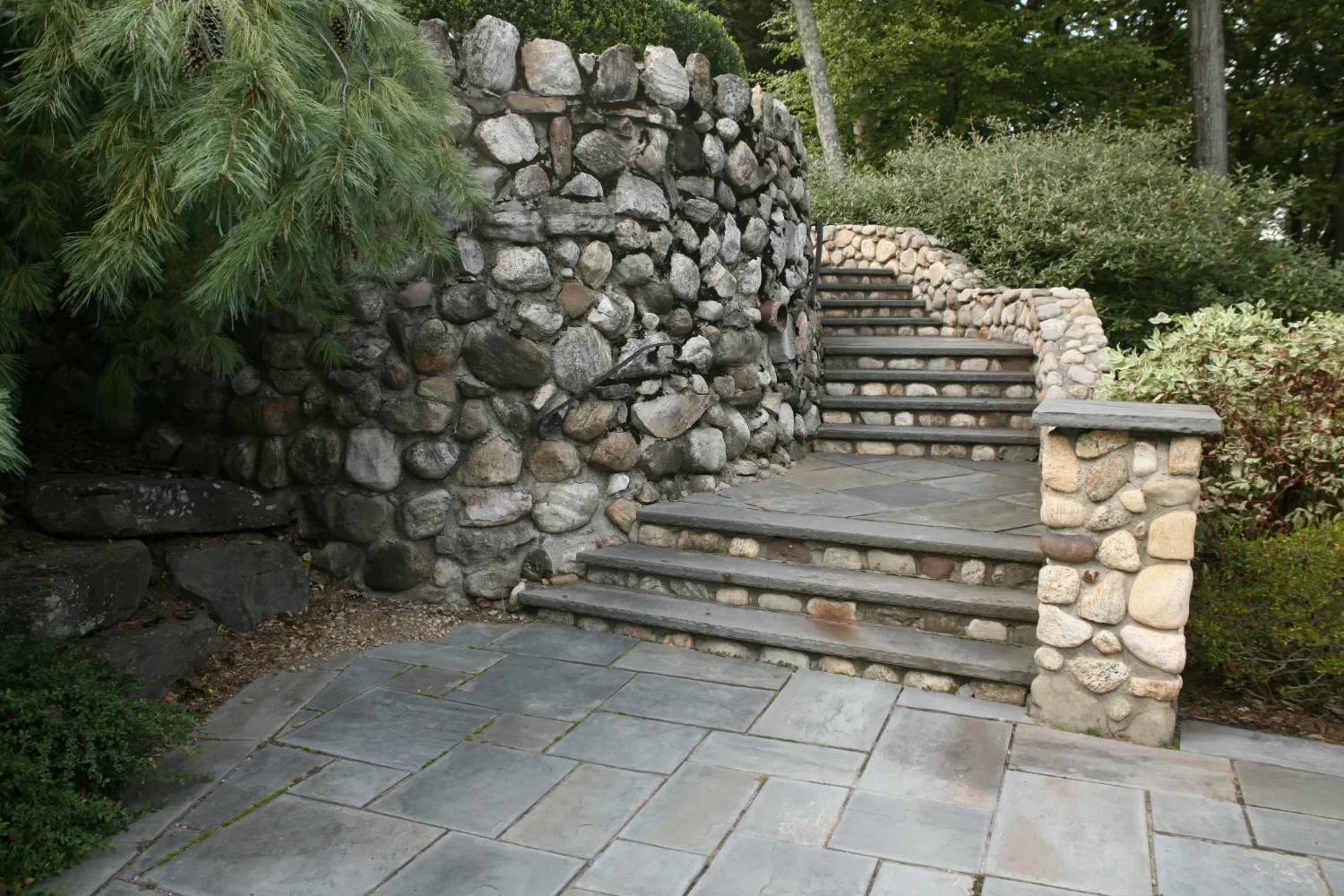 Retaining wall built into a slope to create usable lawn space in Upper Saddle River, NJ