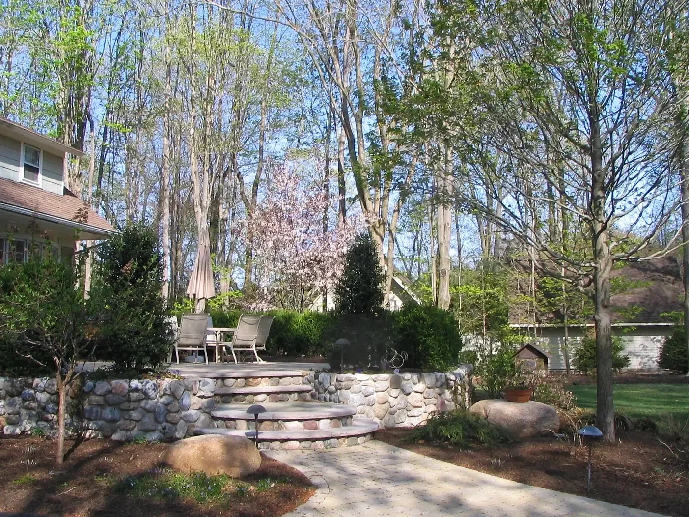 Retaining wall integrated into a poolside landscape with layered plantings in Ridgewood, NJ