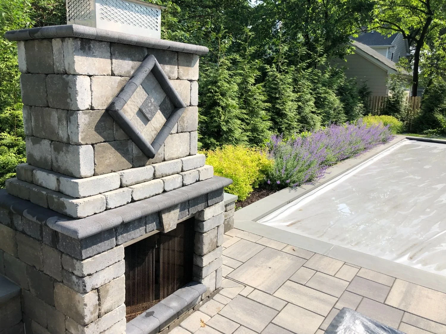 The patio design centers around a fire pit built with stacked stone in Glen Rock, NJ