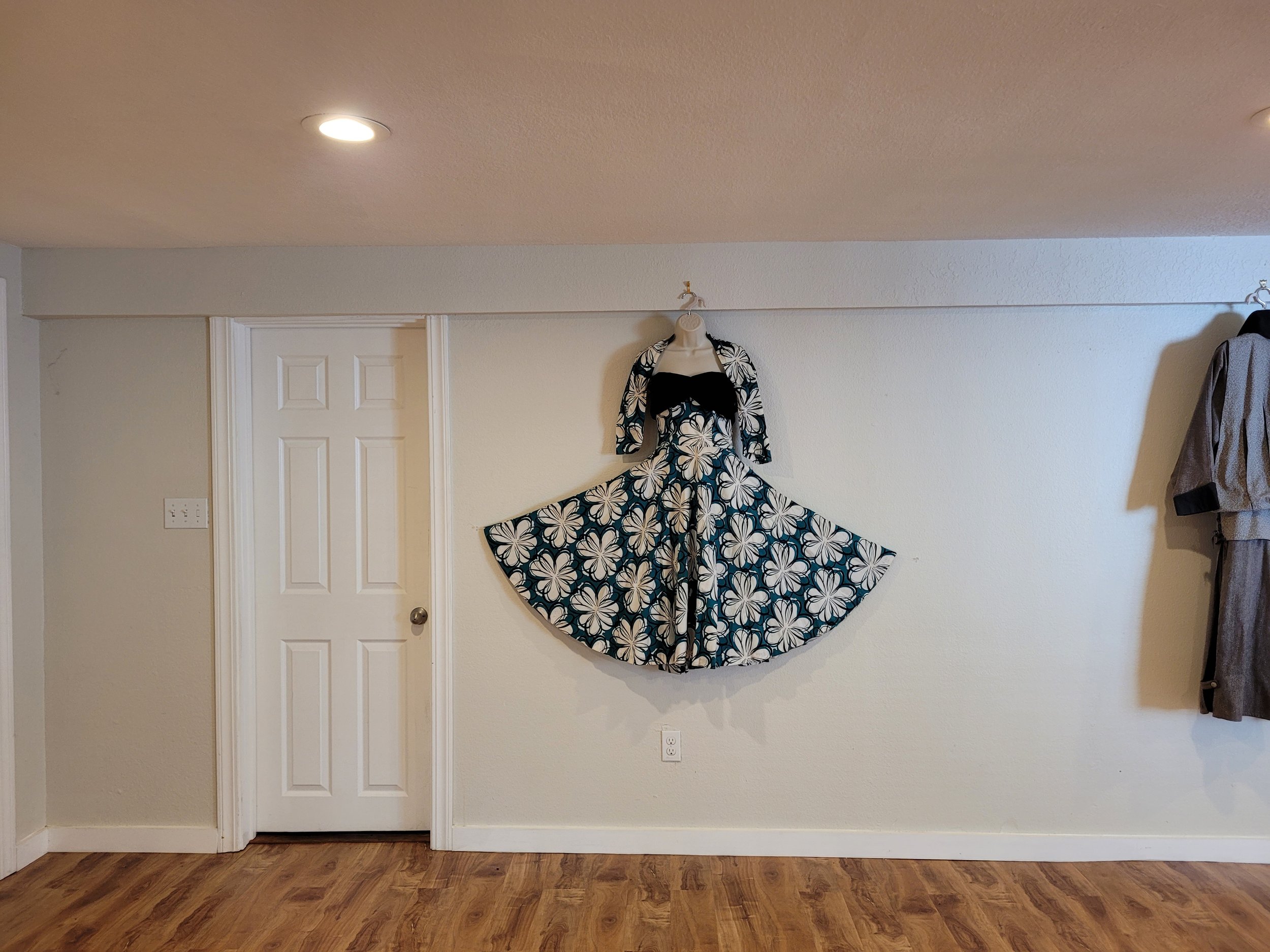 Vintage-style floral dress on mannequin against white wall