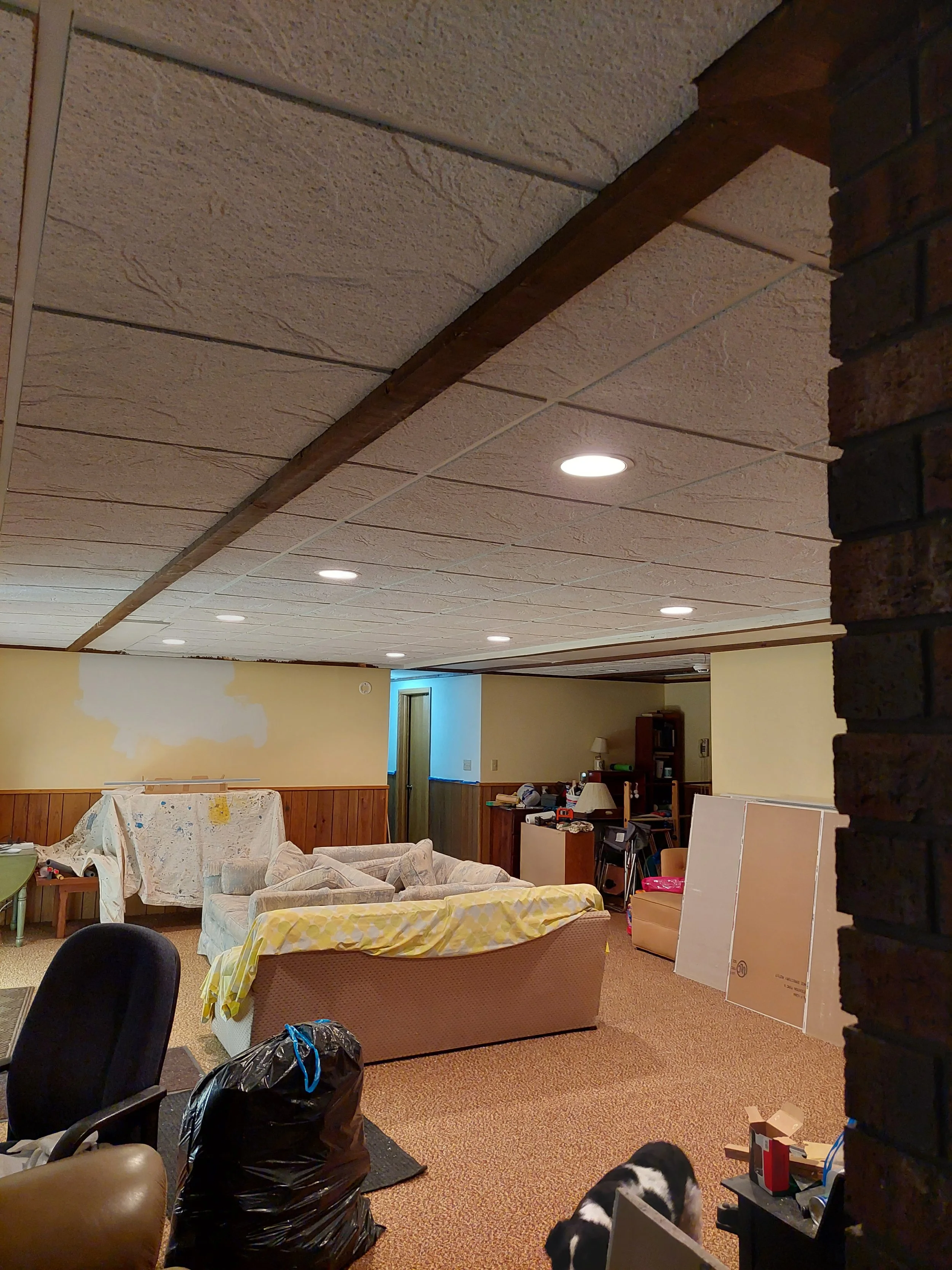 Basement room under renovation with new drop ceiling.