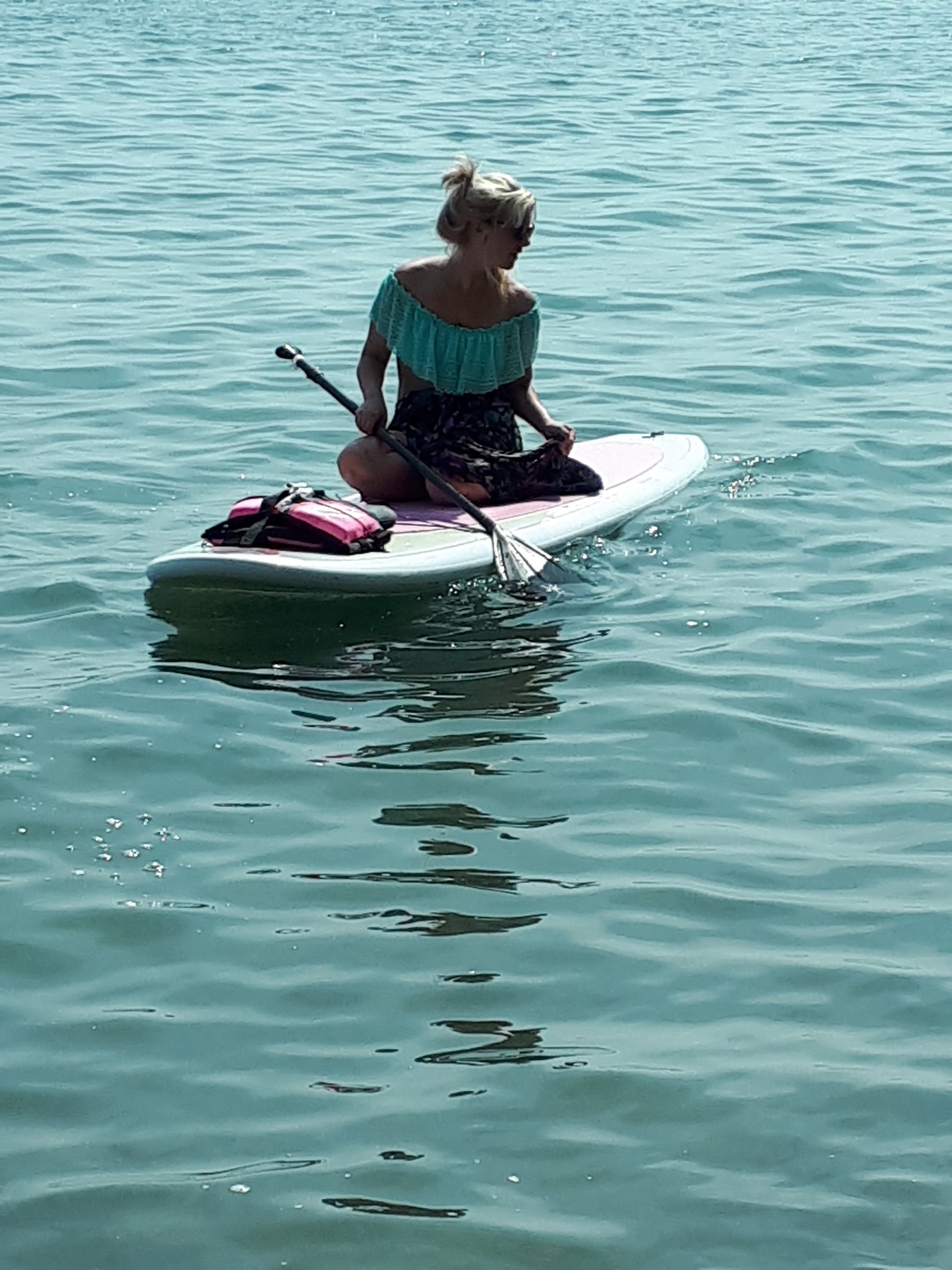 Person sitting on a paddleboard in calm water
