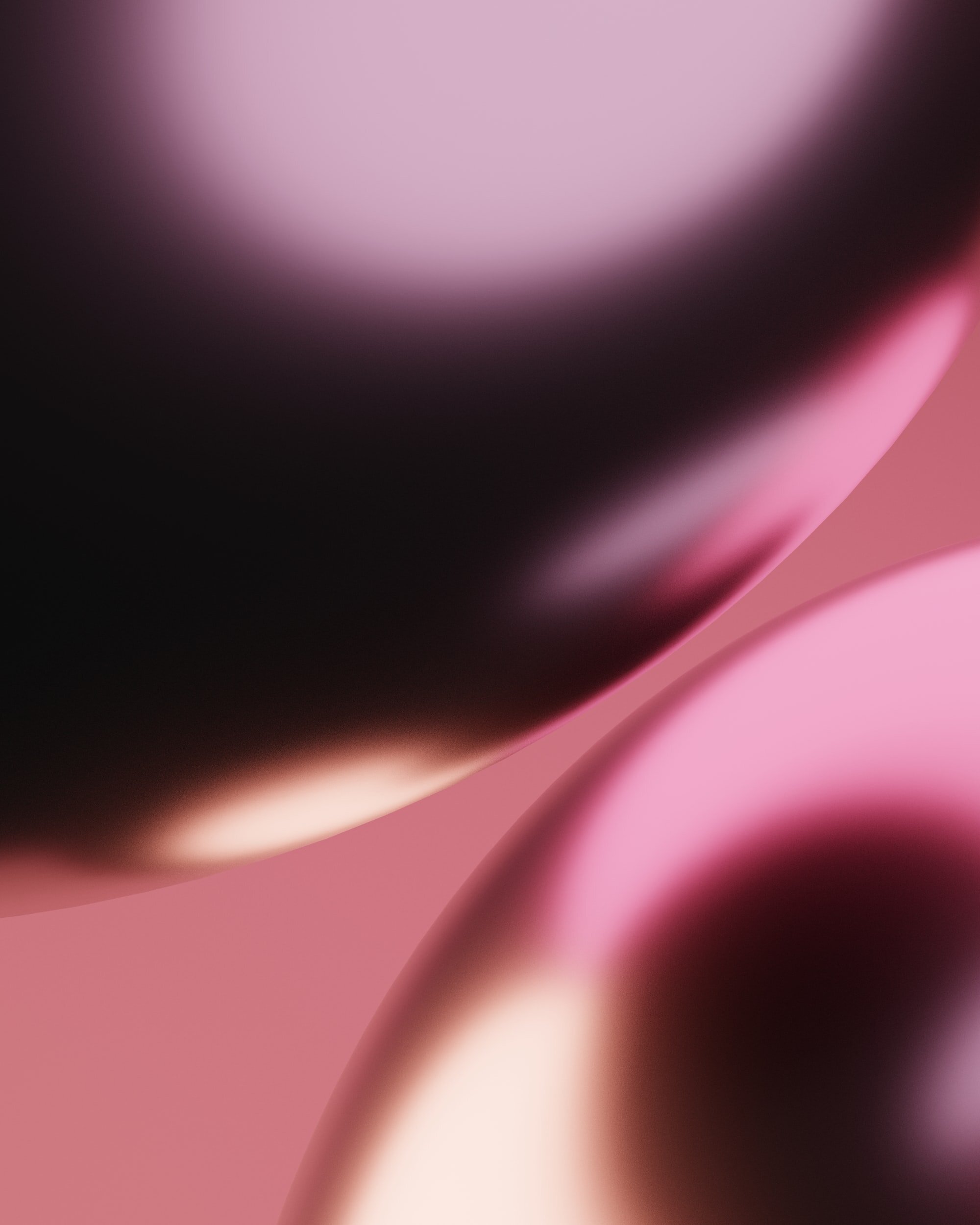 Close-up of a pink and black metallic abstract object with smooth, curved surfaces.