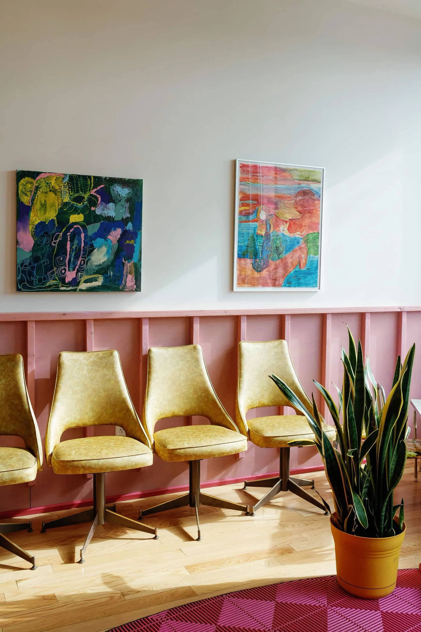 A row of chairs against a pink wall