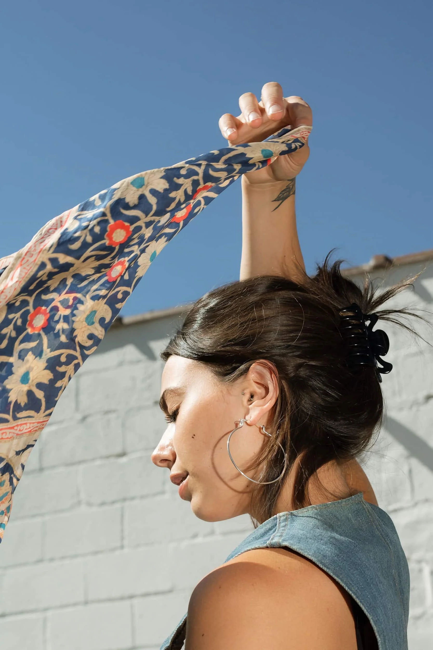 A woman waving a silk scarf in the wind