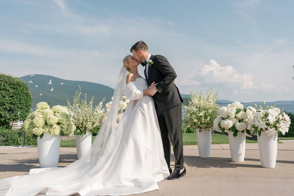 A bride and groom share first kiss at their Adirondack wedding ceremony at The Sagamore Resort on Lake George