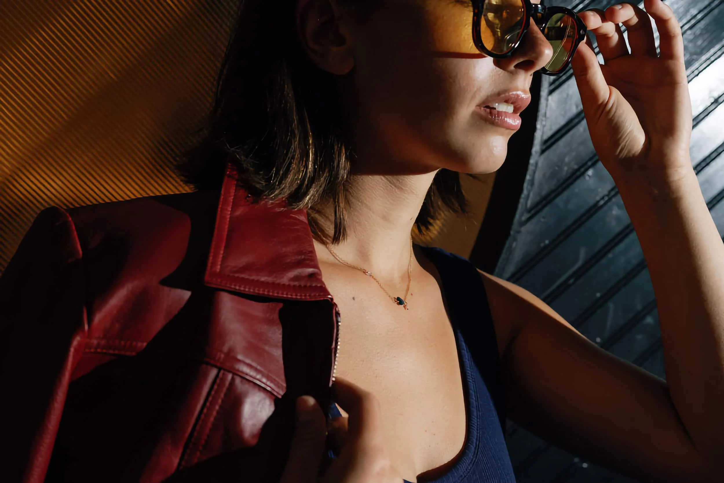 Moody closeup of a woman with sunglasses and a leather jacket