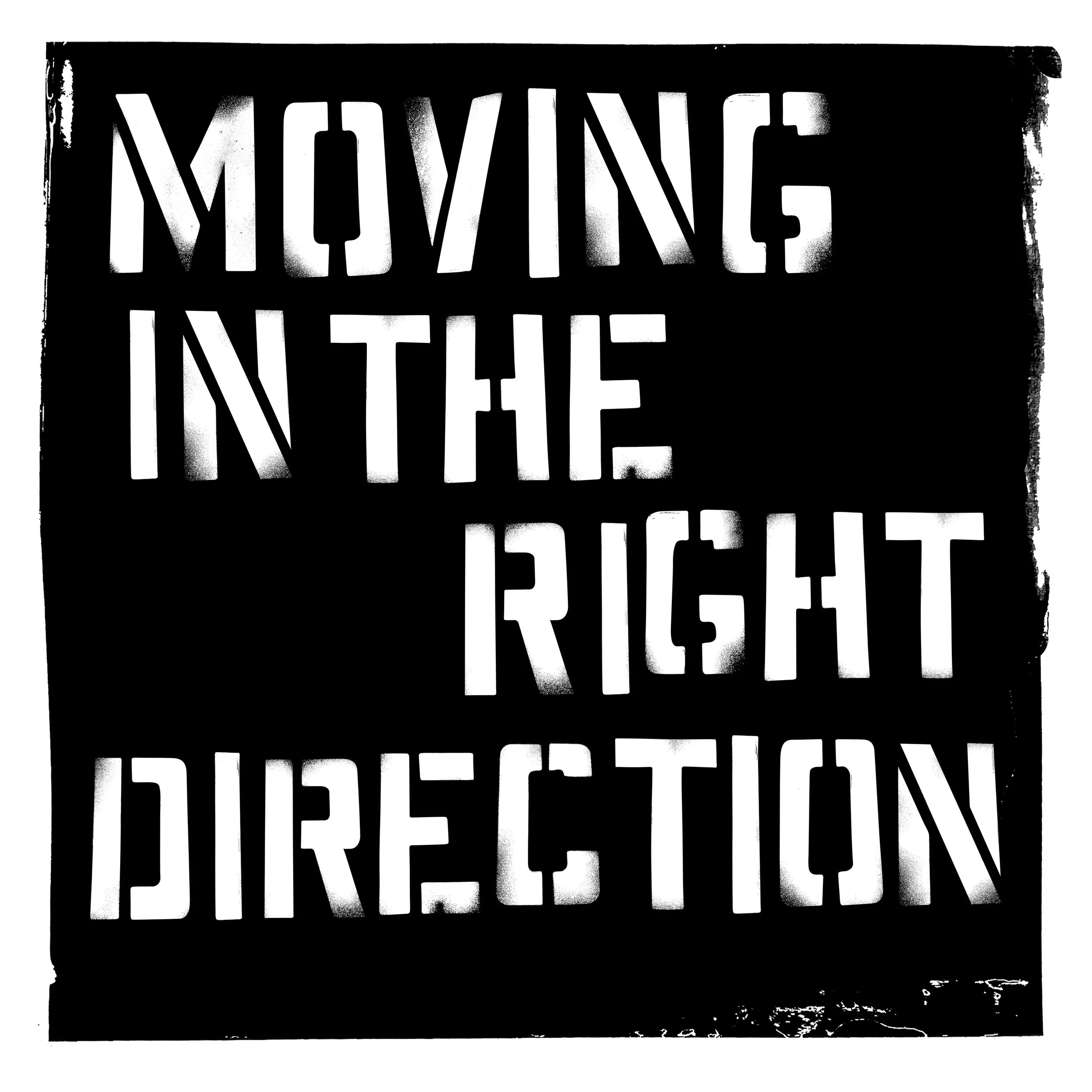 Stencil-style sign with the phrase 'Moving in the right direction' in bold, white letters on a black background.