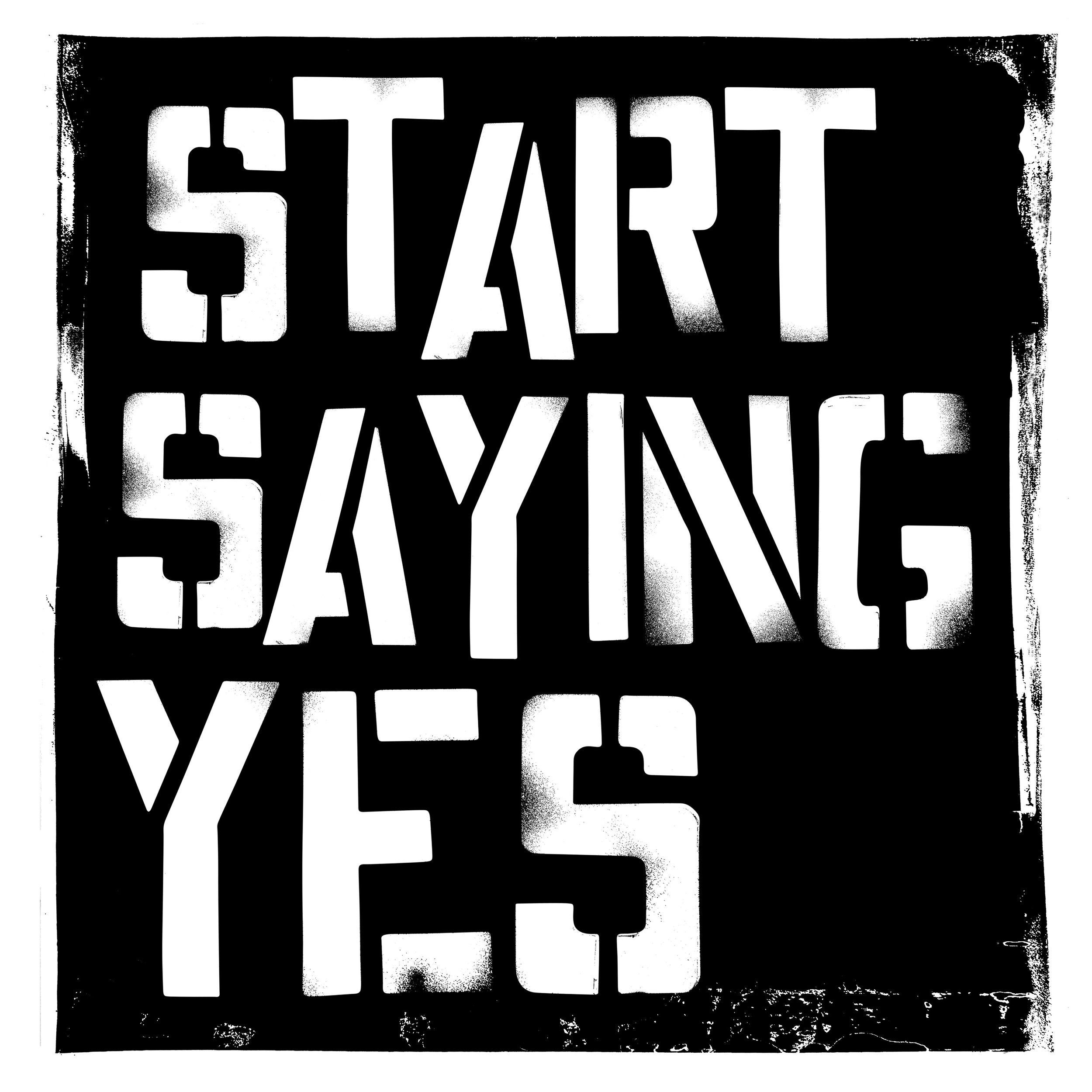 A black and white stencil-style sign with the words "START SAYING YES" in large, bold, capital letters.