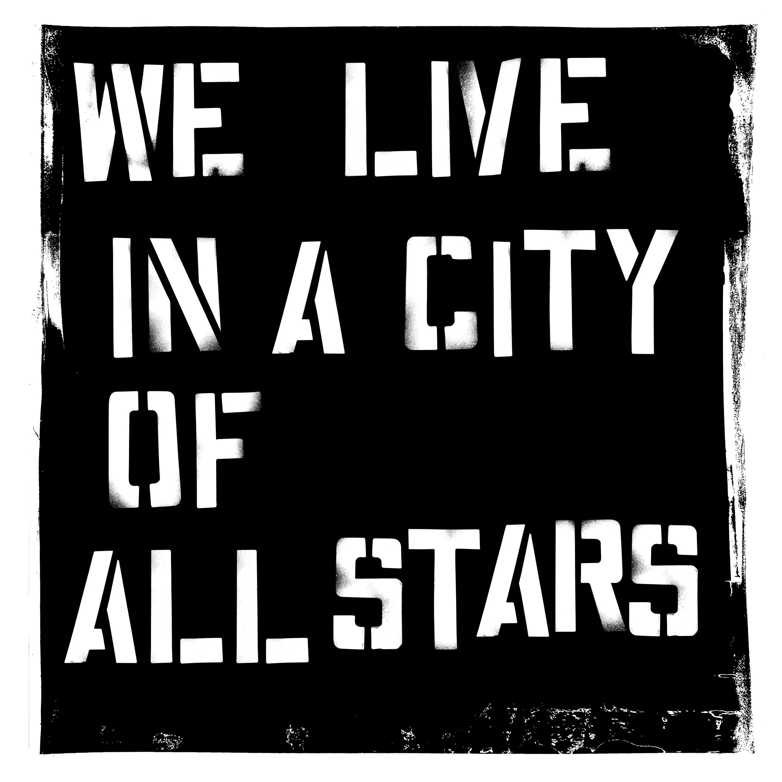 Black and white graffiti-style wall art with the phrase 'We live in a city of all stars' in large, bold letters.