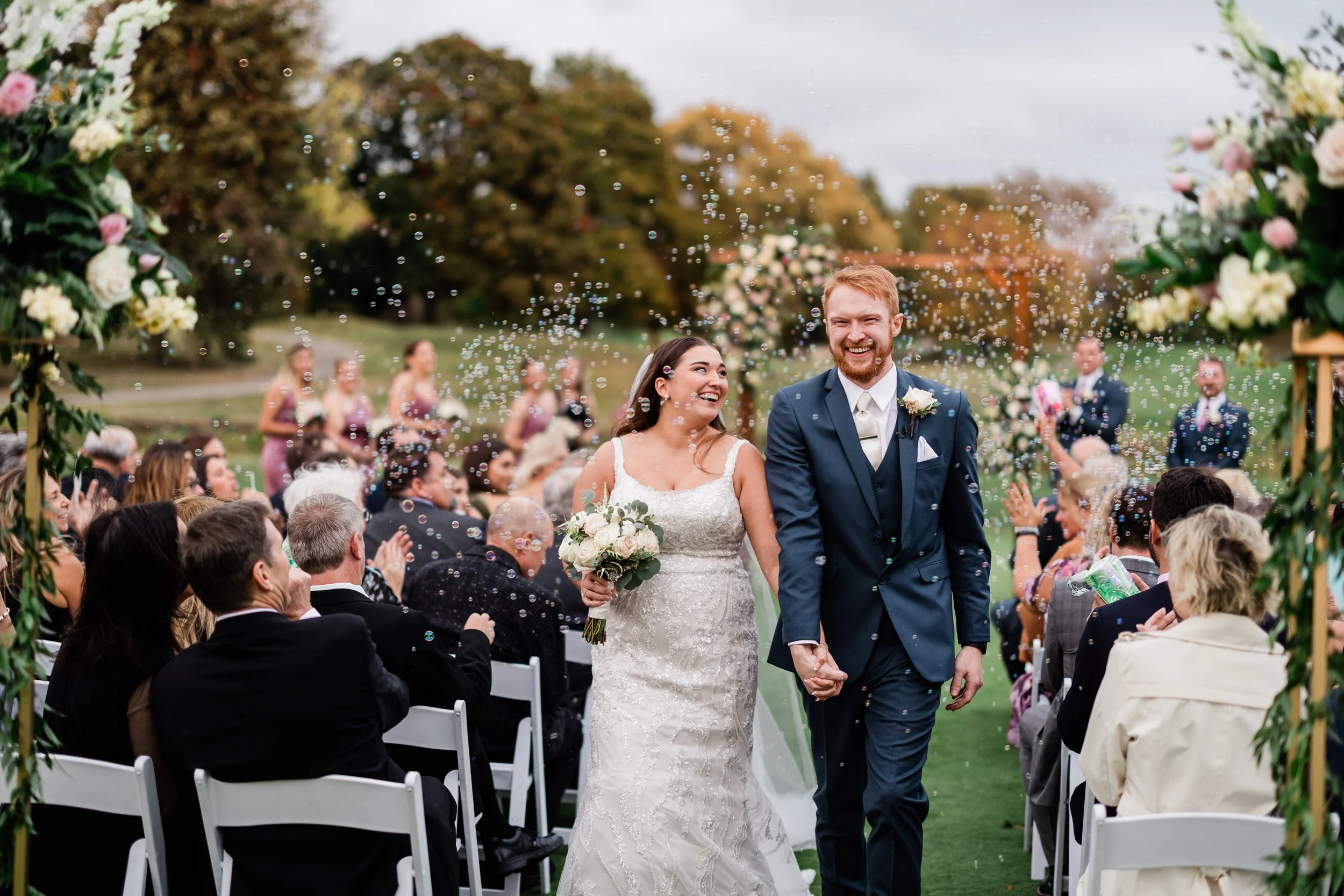 A newly married bride and groom celebrating their outdoor wedding ceremony on the golf course at Itasca Country Club in Itasca, IL, with stress-free planning by One Fine Day Events.